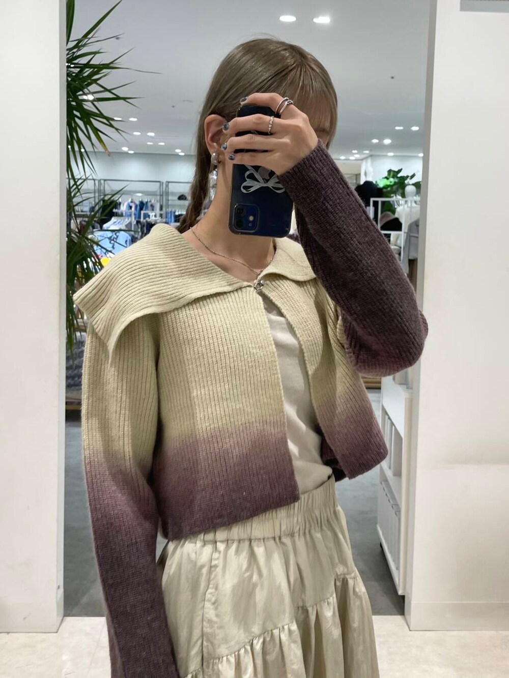 ベージュ系のキャミソール、ブラウン系のニット/セーター、ベージュ系のハンドバッグを着用したレディースの秋コーディネートの6枚目の写真