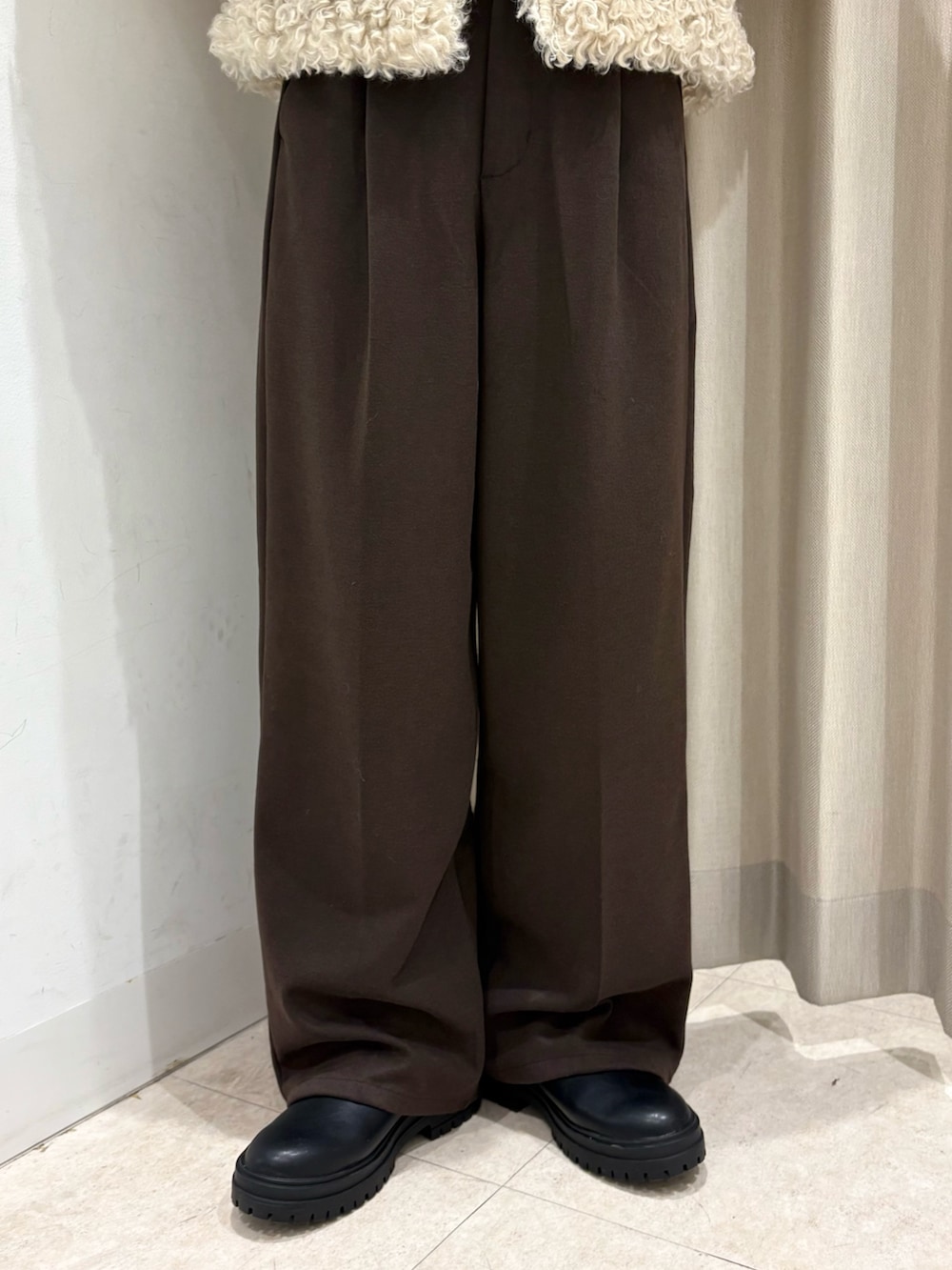 ホワイト系のその他アウター、ベージュ系のニット/セーター、ブラウン系のその他パンツを着用したレディースの冬コーディネートの3枚目の写真