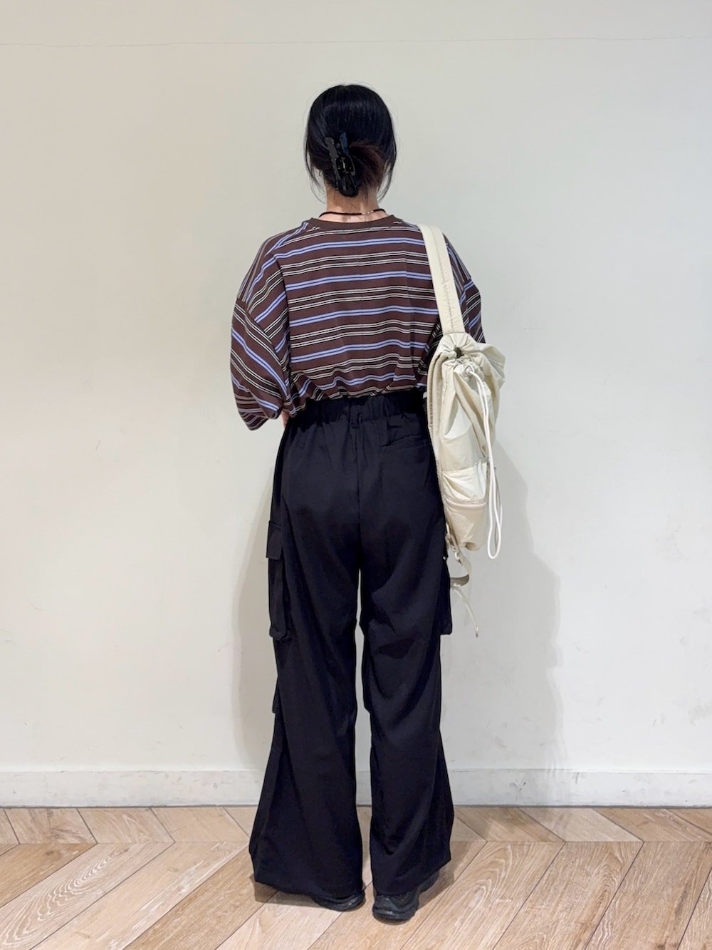 ブラック系のその他パンツ、ベージュ系のバックパック/リュックを着用したレディースの春コーディネートの2枚目の写真