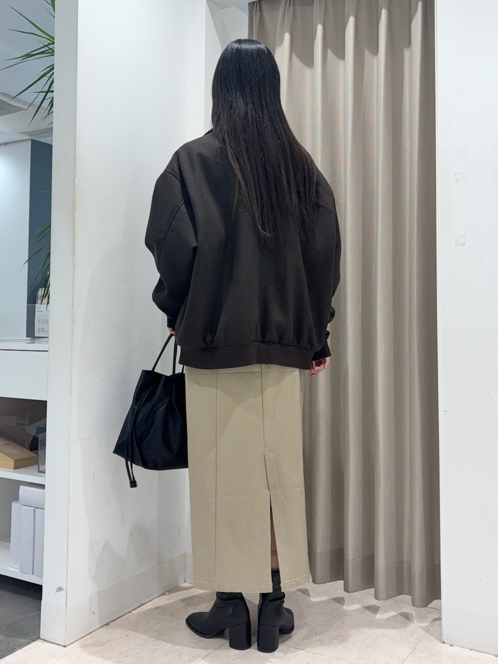 ブラウン系のブルゾン、ブルー系のニット/セーター、ベージュ系のスカートを着用したレディースの冬コーディネートの2枚目の写真