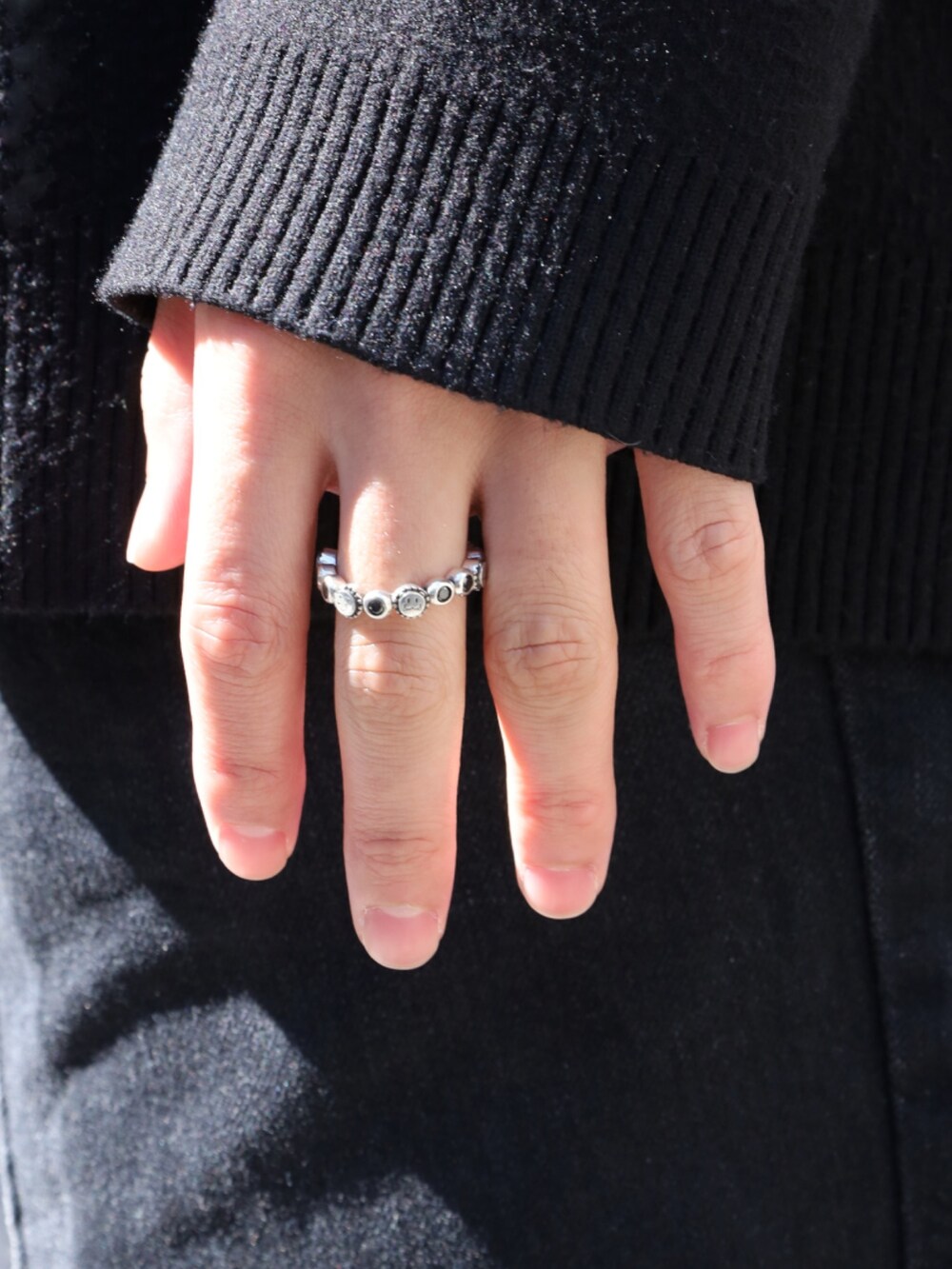 ブラック系のカーディガン/ボレロ、グレー系のスニーカー、ブラック系のデニムパンツを着用したメンズの春コーディネートの4枚目の写真