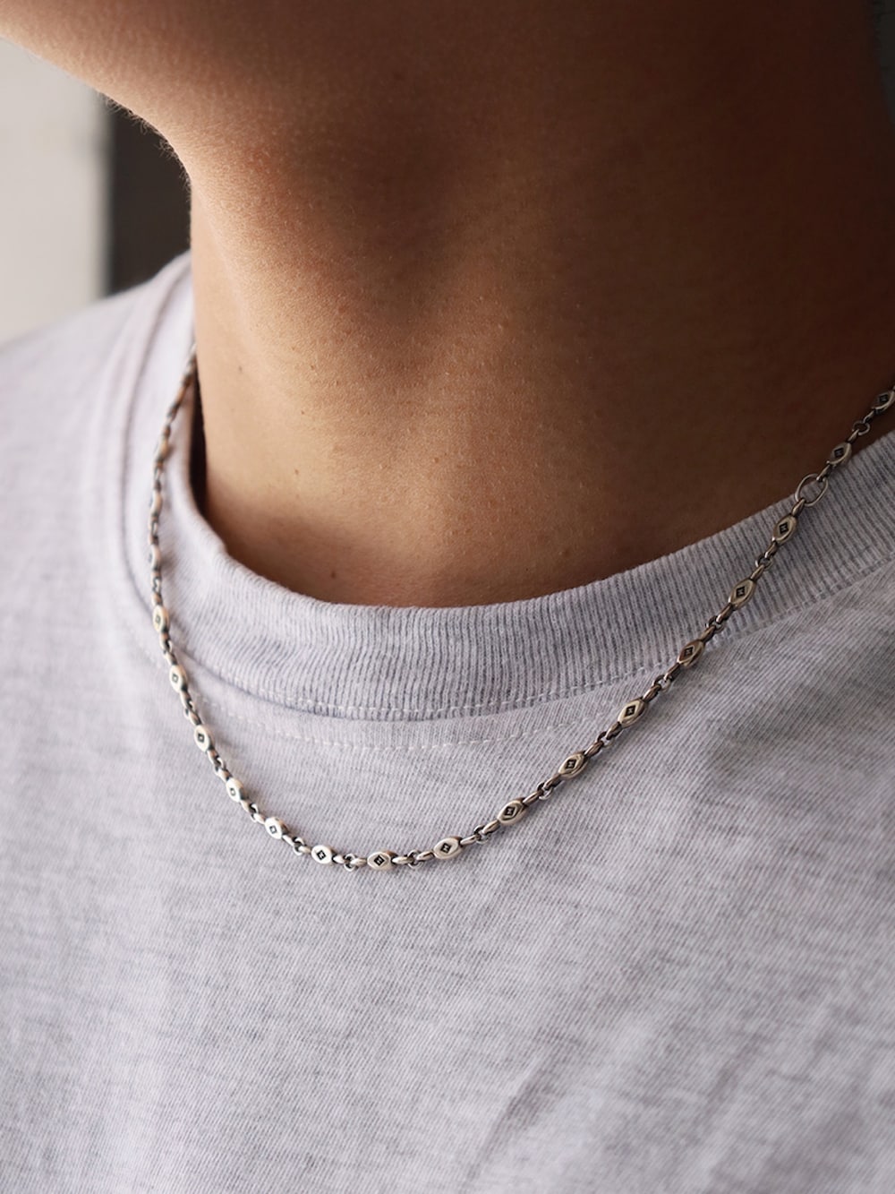 グレー系のTシャツ/カットソー、ブラック系のパンツ、ブラック系のスリッポンを着用したメンズの春コーディネートの2枚目の写真