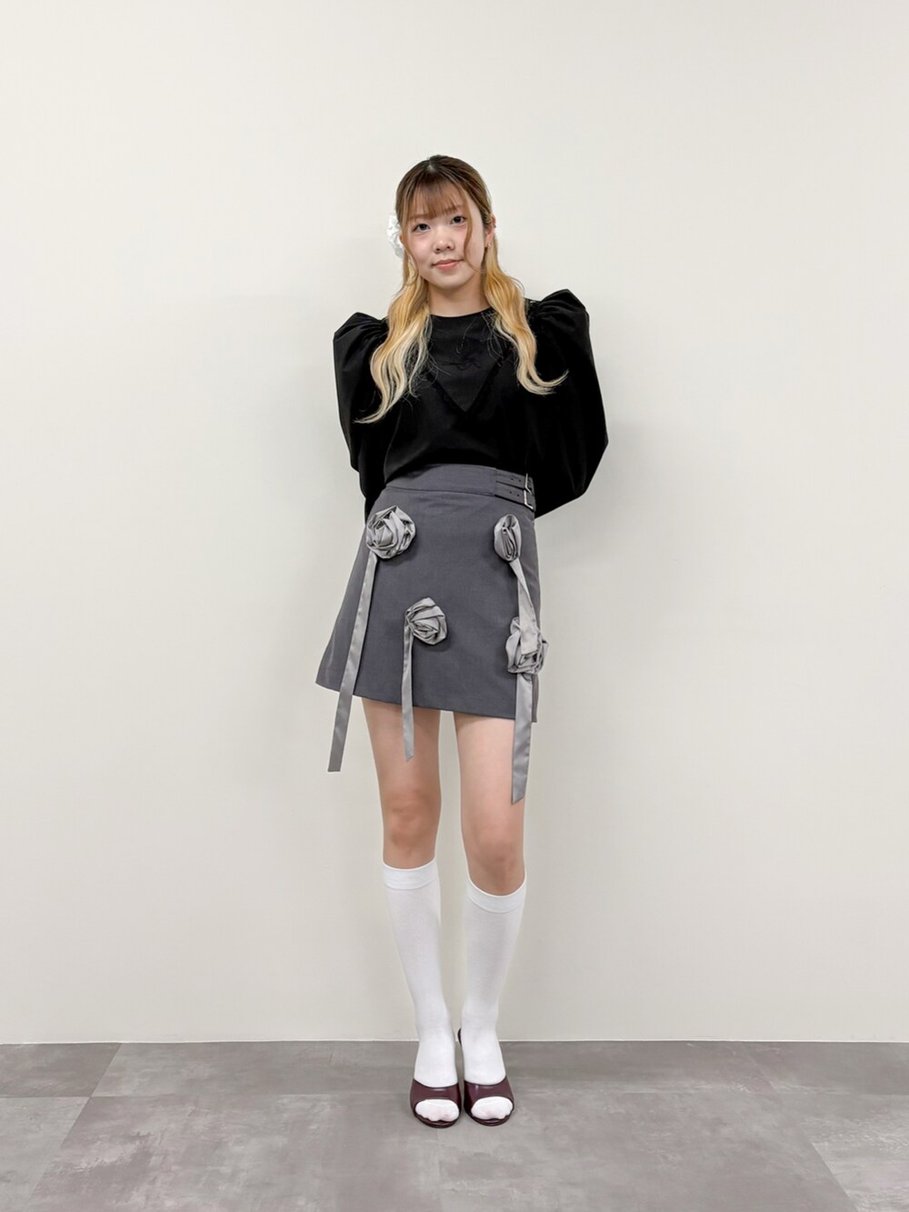 グレー系のスカート、ブラック系のシャツ/ブラウスを着用したレディースの春コーディネートの2枚目の写真