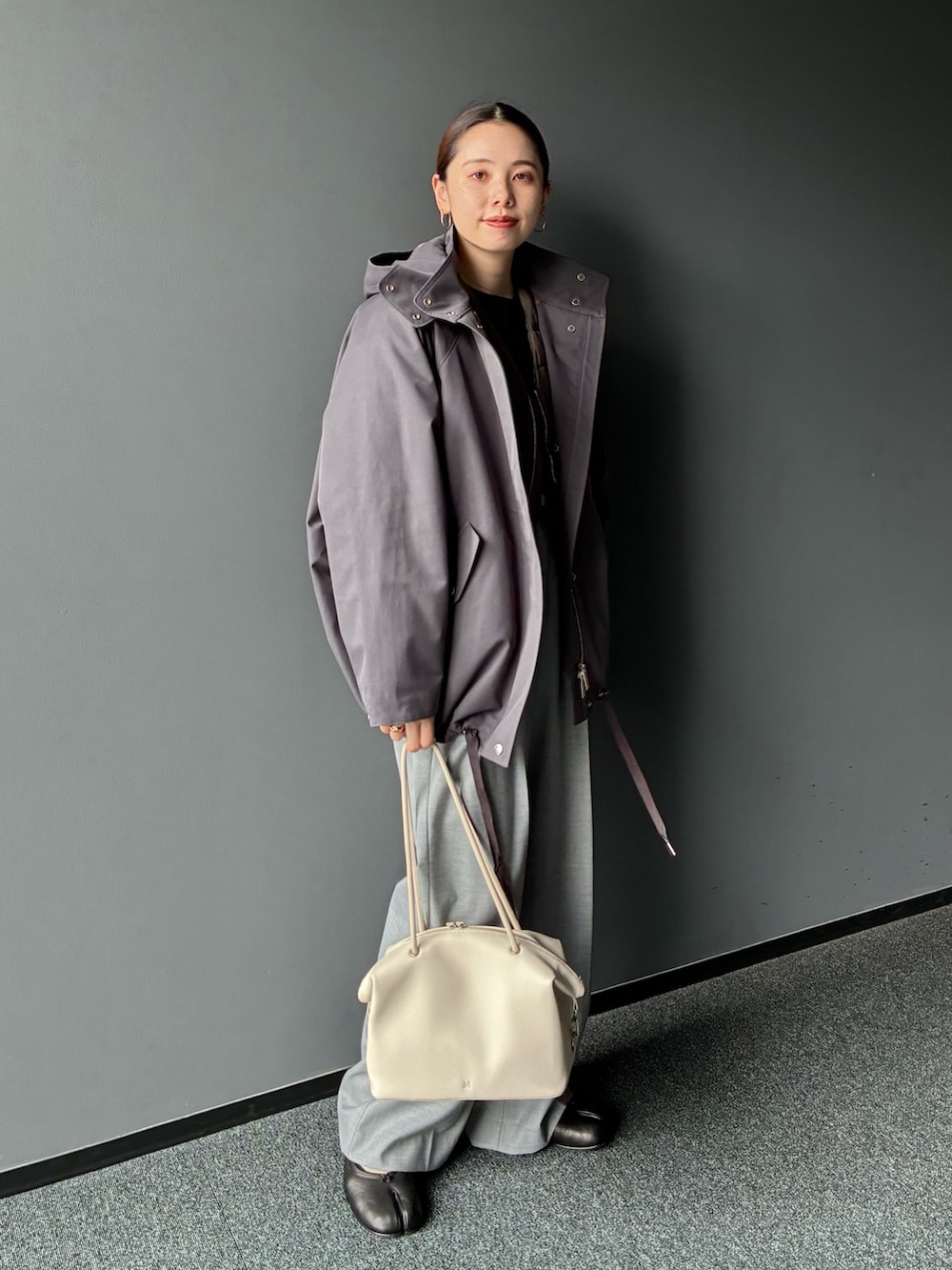 グレー系のダウンジャケット/コート、グレー系のスラックス、ホワイト系のトートバッグを着用したレディースの秋コーディネートの4枚目の写真