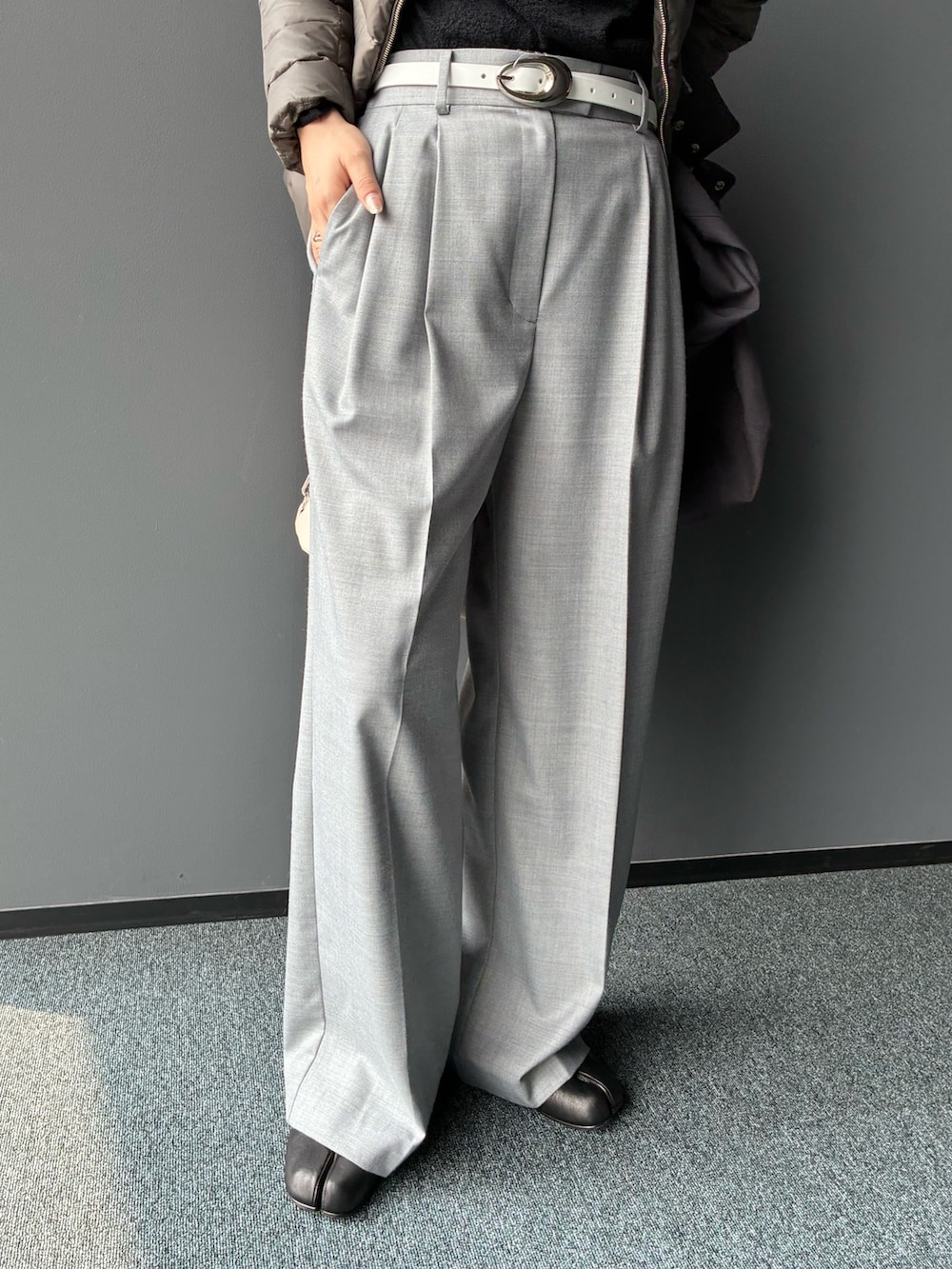 グレー系のダウンジャケット/コート、グレー系のスラックス、ホワイト系のトートバッグを着用したレディースの秋コーディネートの7枚目の写真