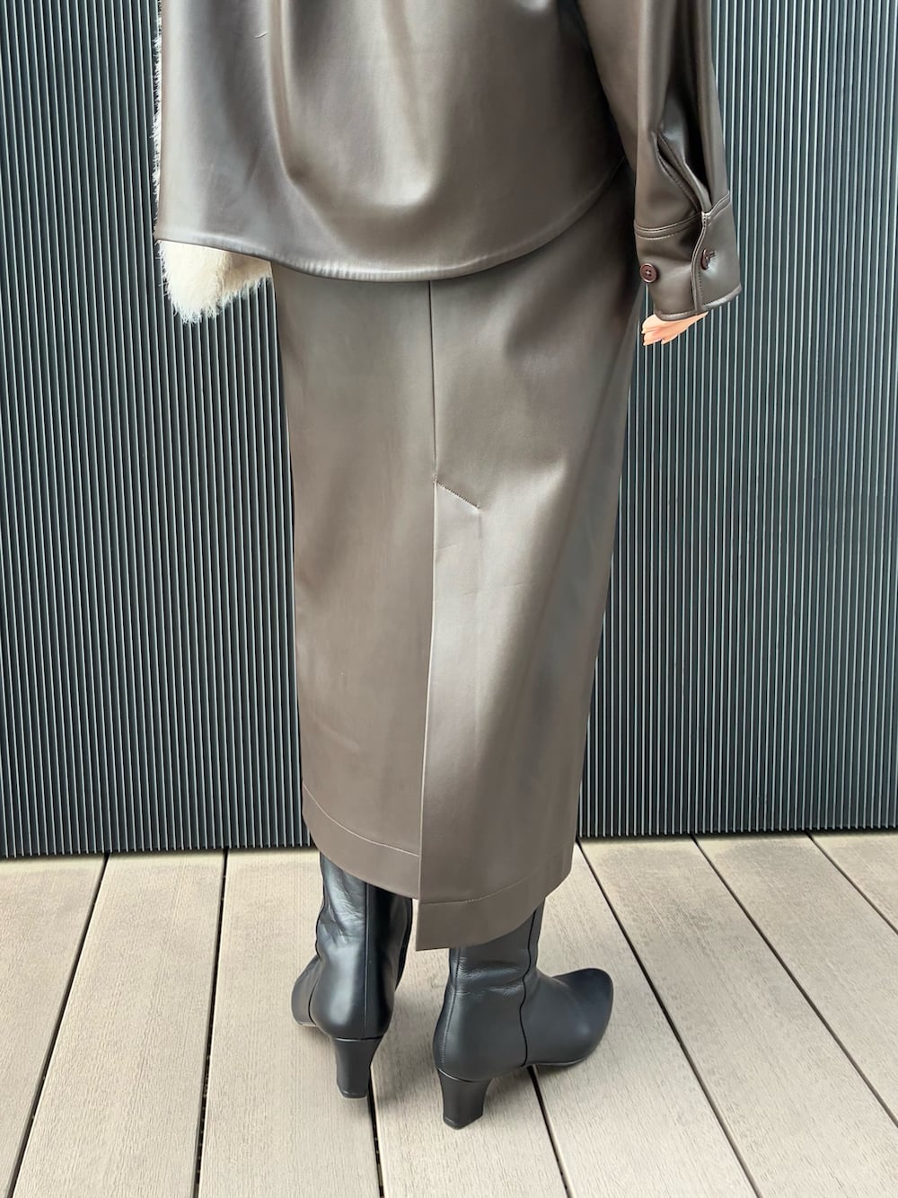 ホワイト系のベスト、ブラウン系のブルゾン、ブラウン系のスカートを着用したレディースの秋コーディネートの7枚目の写真