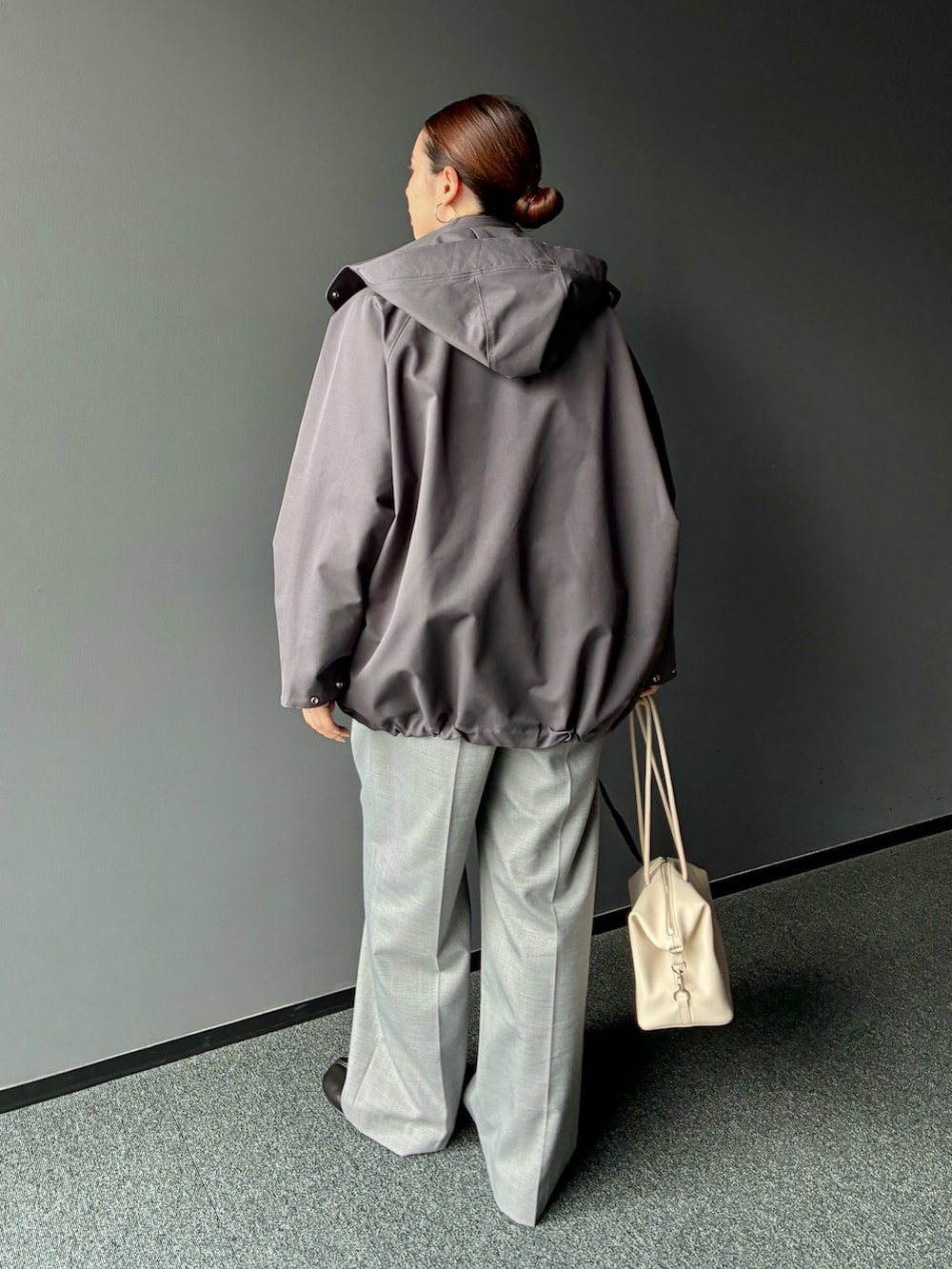 グレー系のダウンジャケット/コート、グレー系のスラックス、ホワイト系のトートバッグを着用したレディースの秋コーディネートの3枚目の写真