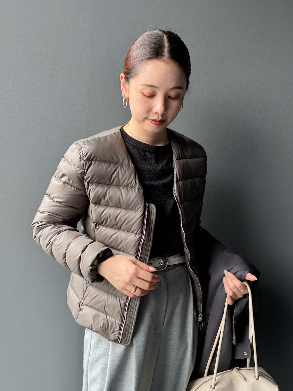 グレー系のダウンジャケット/コート、グレー系のスラックス、ホワイト系のトートバッグを着用したレディースの秋コーディネートの6枚目の写真