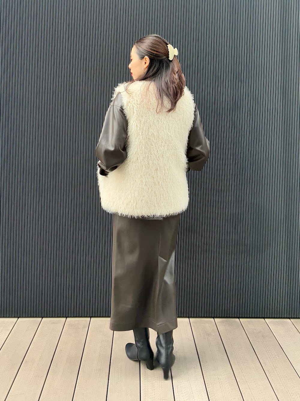 ホワイト系のベスト、ブラウン系のブルゾン、ブラウン系のスカートを着用したレディースの秋コーディネートの3枚目の写真