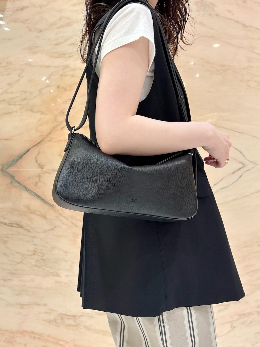 ブラック系のベスト、ベージュ系のその他パンツ、ブラック系のトートバッグを着用したレディースの夏コーディネートの6枚目の写真