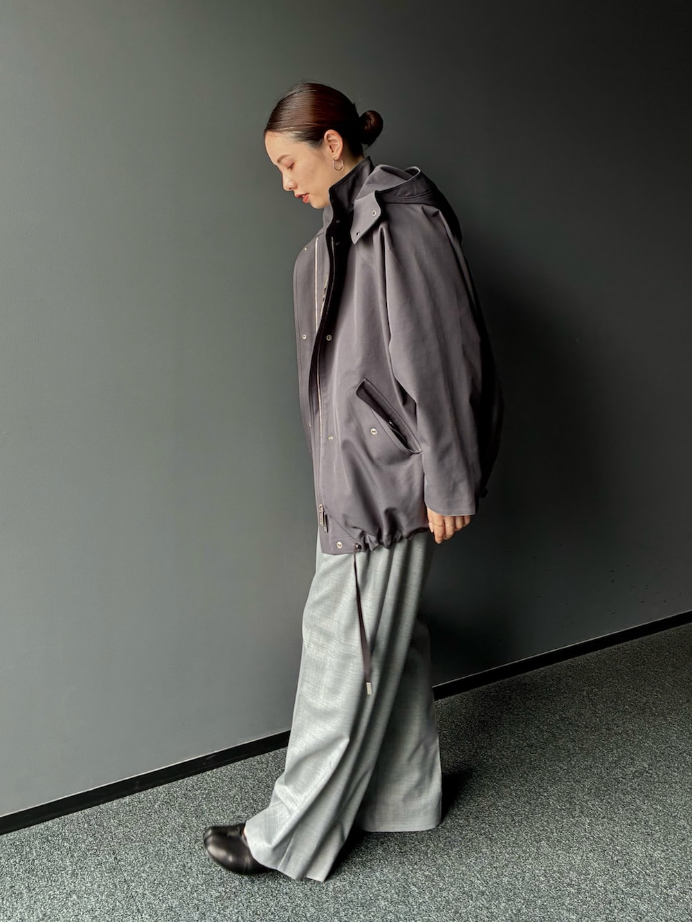 グレー系のダウンジャケット/コート、グレー系のスラックス、ホワイト系のトートバッグを着用したレディースの秋コーディネートの2枚目の写真