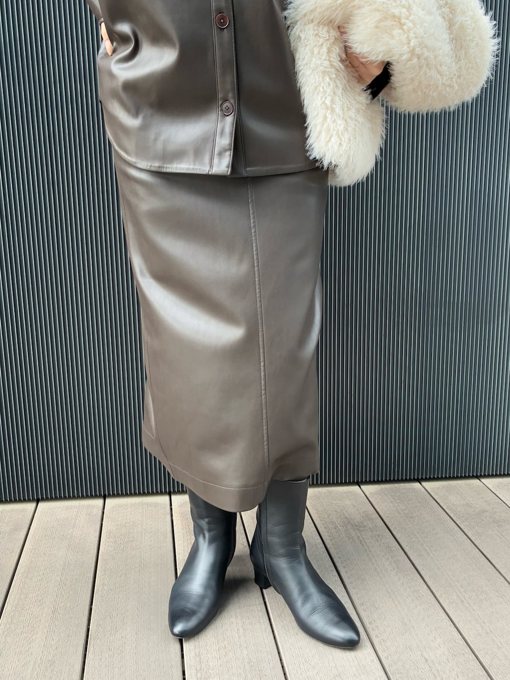 ホワイト系のベスト、ブラウン系のブルゾン、ブラウン系のスカートを着用したレディースの秋コーディネートの6枚目の写真