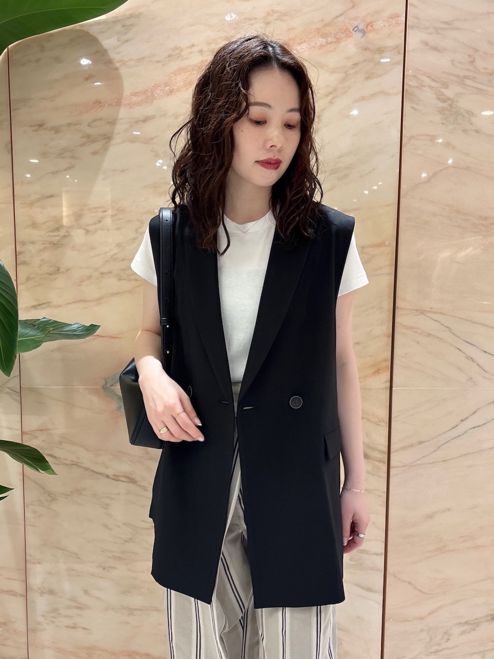 ブラック系のベスト、ベージュ系のその他パンツ、ブラック系のトートバッグを着用したレディースの夏コーディネートの3枚目の写真