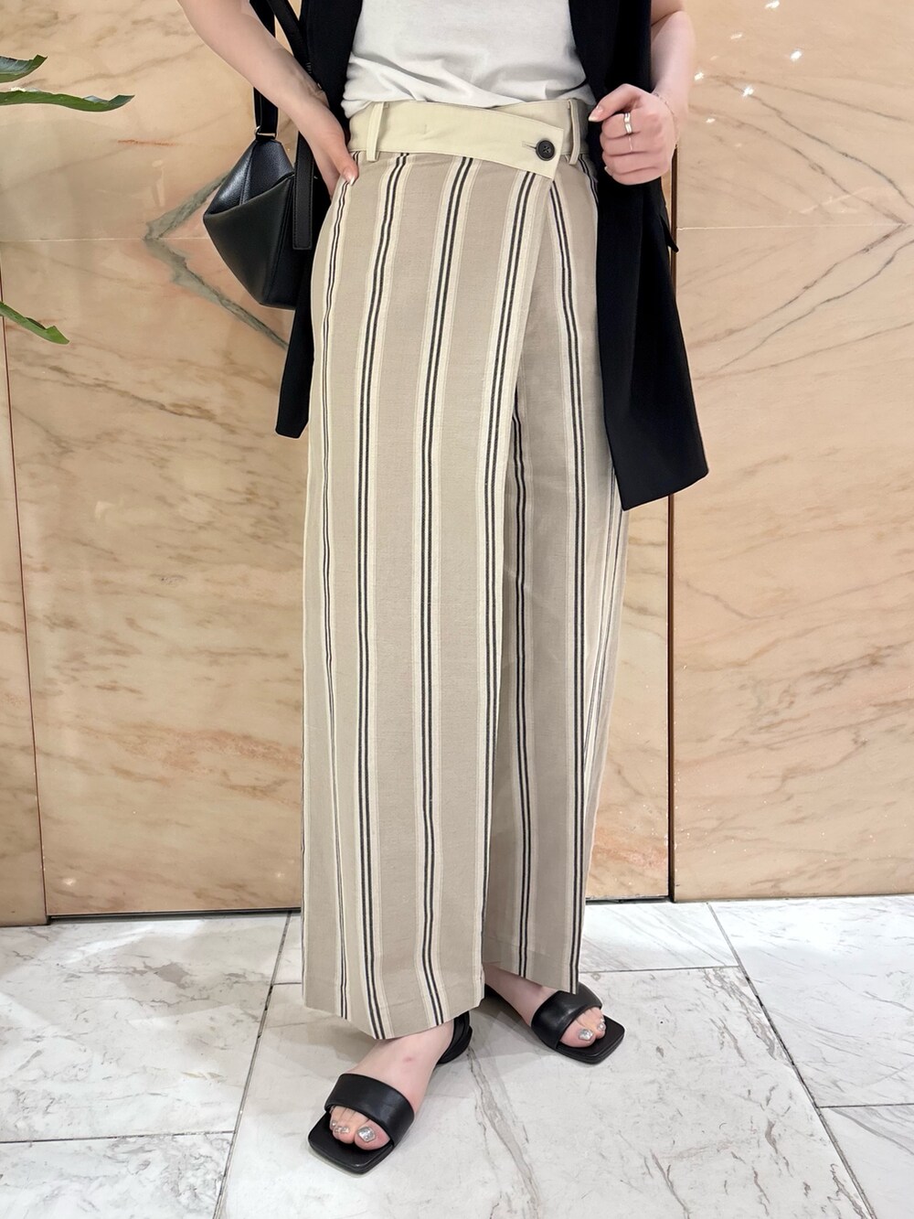 ブラック系のベスト、ベージュ系のその他パンツ、ブラック系のトートバッグを着用したレディースの夏コーディネートの5枚目の写真