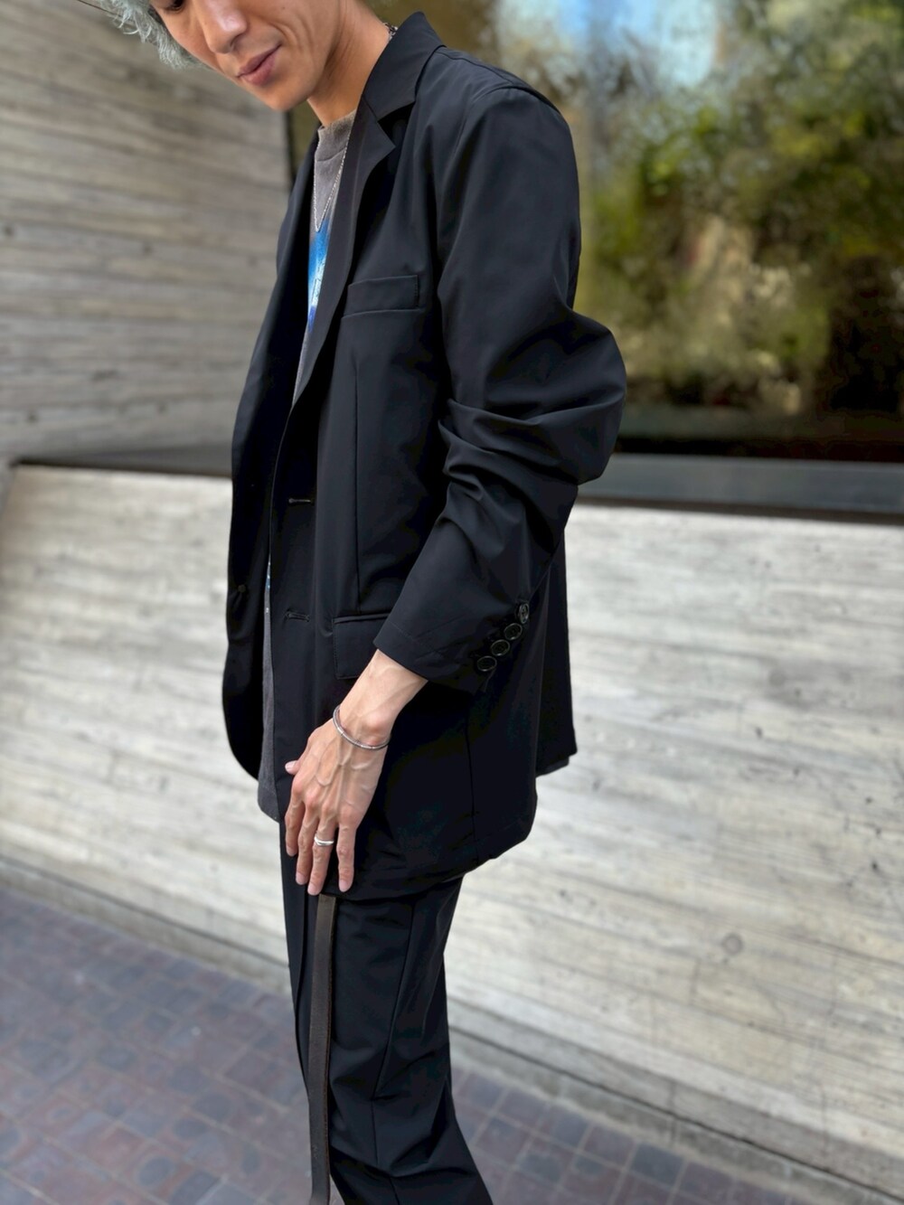 ブラック系のテーラードジャケット、ブラック系のその他パンツを着用したメンズの夏コーディネートの2枚目の写真