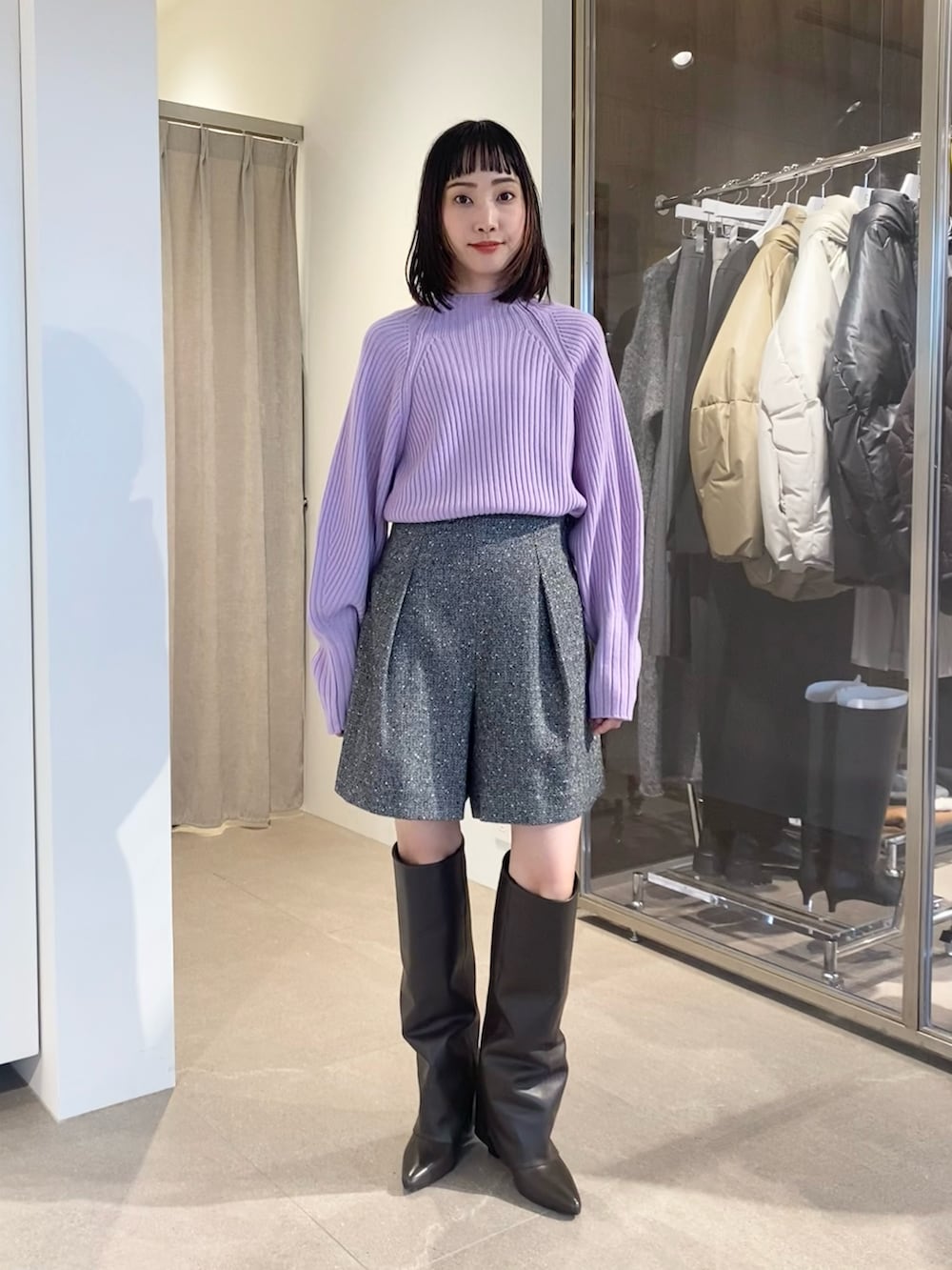 パープル系のニット/セーター、ブラック系のスラックス、ブラウン系のボストンバッグを着用したレディースの秋コーディネートの2枚目の写真