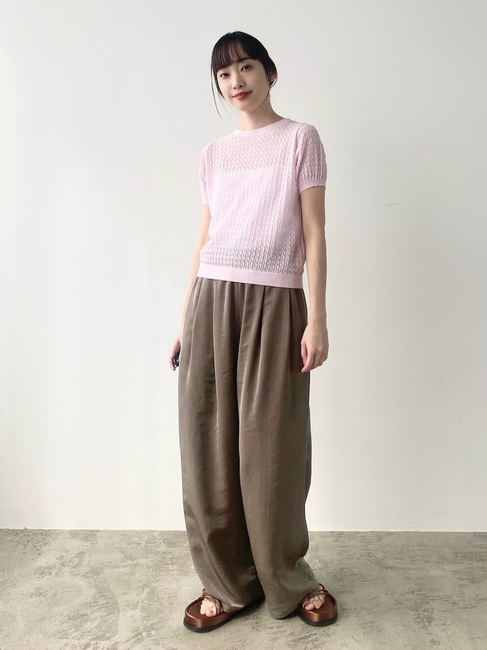 ピンク系のニット/セーター、ベージュ系のブルゾン、オレンジ系のサンダルを着用したレディースの春コーディネートの2枚目の写真