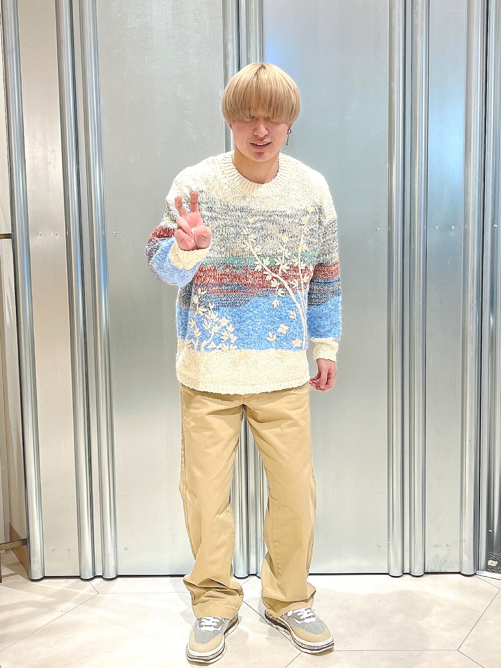 ブラウン系のスニーカー、その他のニット/セーター、ブラウン系のチノパンツを着用したメンズの秋コーディネートの4枚目の写真