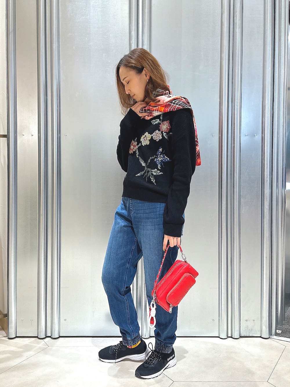 ブラック系のニット/セーター、レッド系のボディバッグ/ウエストポーチ、その他のマフラーを着用したレディースの秋コーディネートの2枚目の写真