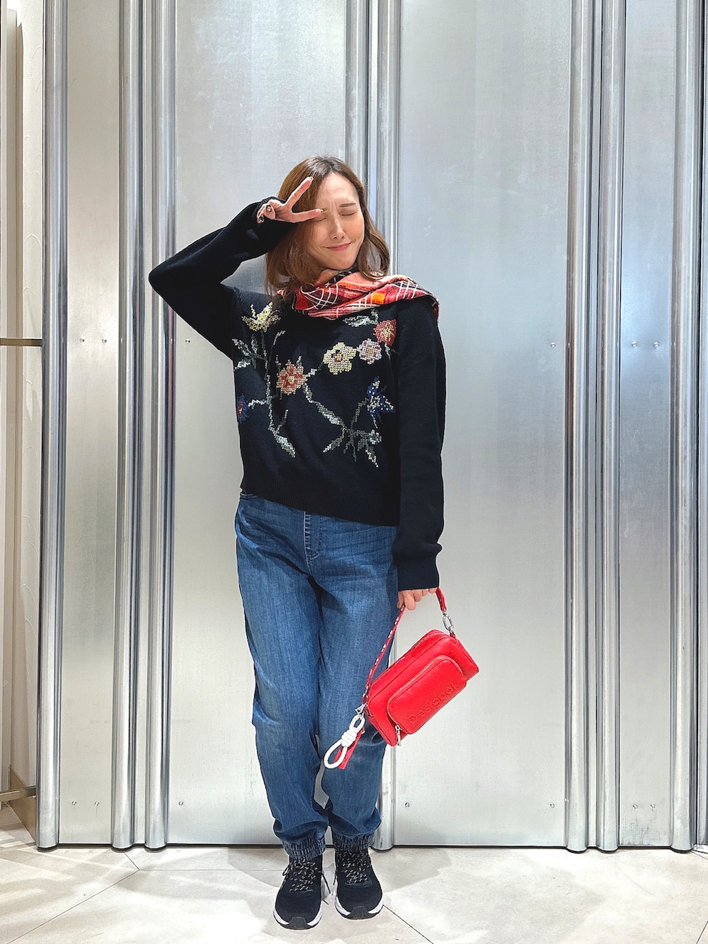 ブラック系のニット/セーター、レッド系のボディバッグ/ウエストポーチ、その他のマフラーを着用したレディースの秋コーディネートの3枚目の写真