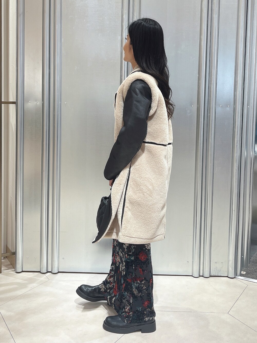 ブラウン系のその他アウター、ブラック系のハンドバッグ、ブラック系のワンピースを着用したレディースの秋コーディネートの2枚目の写真