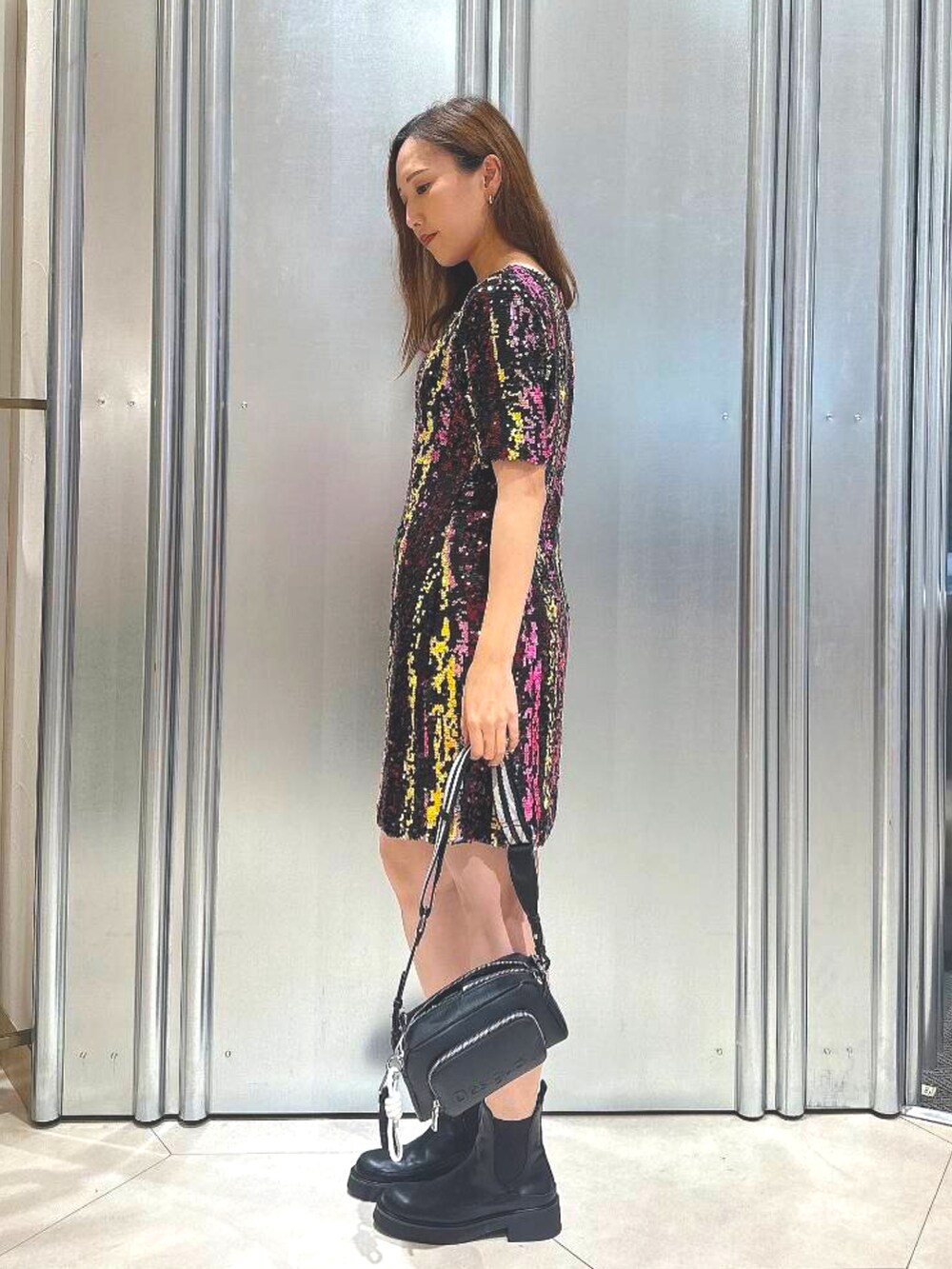 ブラック系のボディバッグ/ウエストポーチ、ブラック系のブーツ、その他のワンピースを着用したレディースの秋コーディネートの2枚目の写真