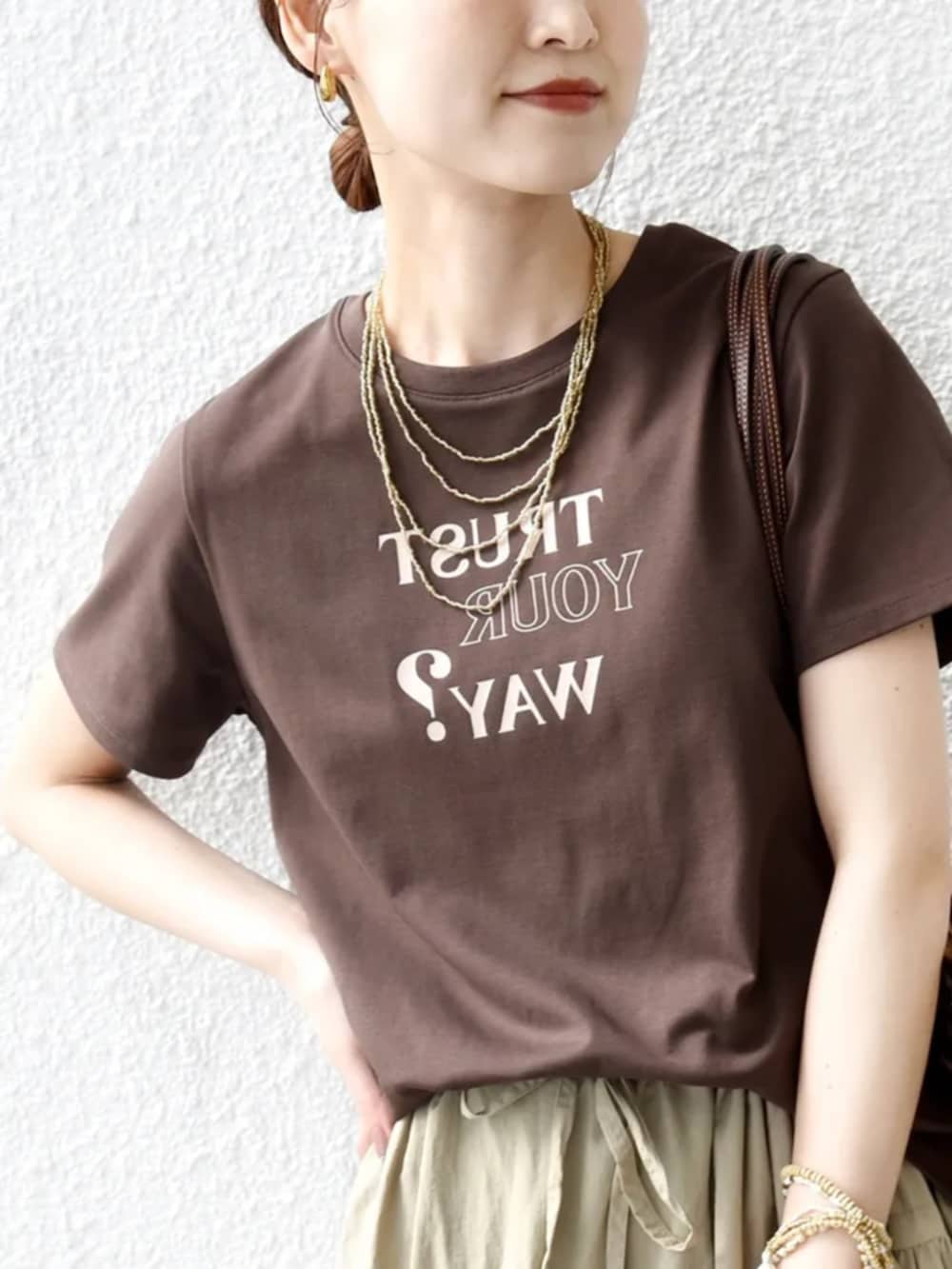 ブラウン系のTシャツ/カットソー、ブラウン系のトートバッグ、ベージュ系のハットを着用したレディースの春コーディネートの4枚目の写真