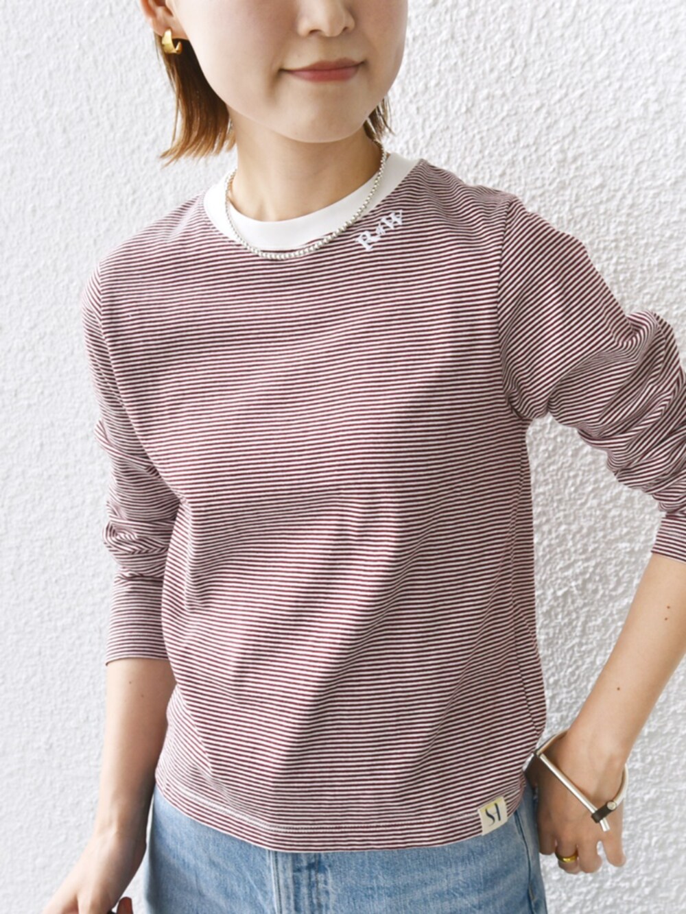 レッド系のTシャツ/カットソーを着用したレディースの秋コーディネートの3枚目の写真