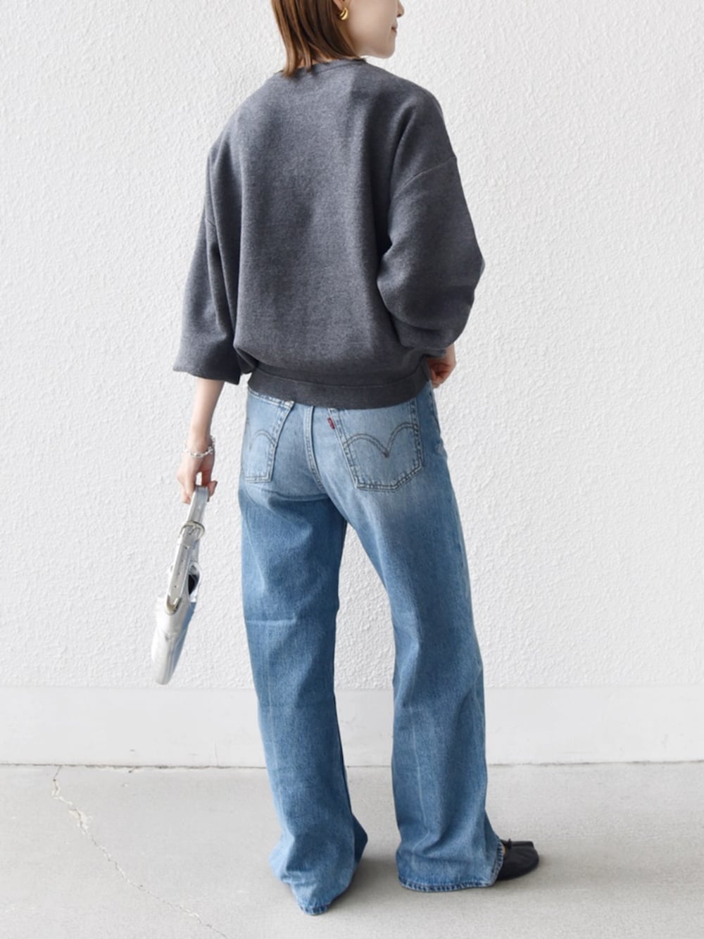 ブルー系のデニムパンツ、グレー系のニット/セーターを着用したレディースの秋コーディネートの3枚目の写真