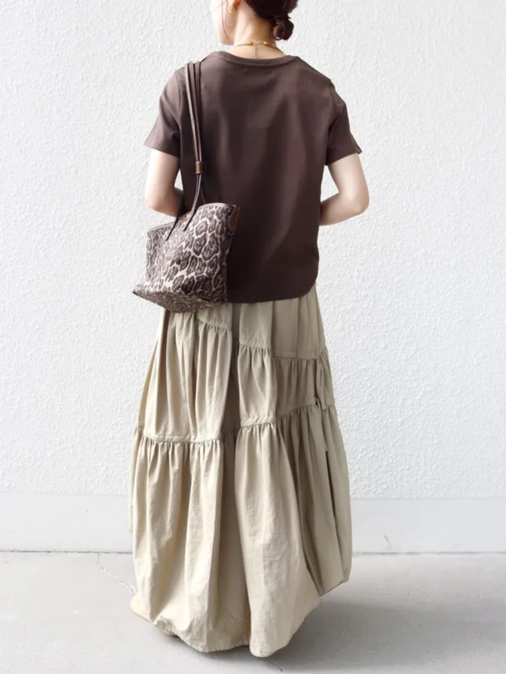 ブラウン系のTシャツ/カットソー、ブラウン系のトートバッグ、ベージュ系のハットを着用したレディースの春コーディネートの3枚目の写真