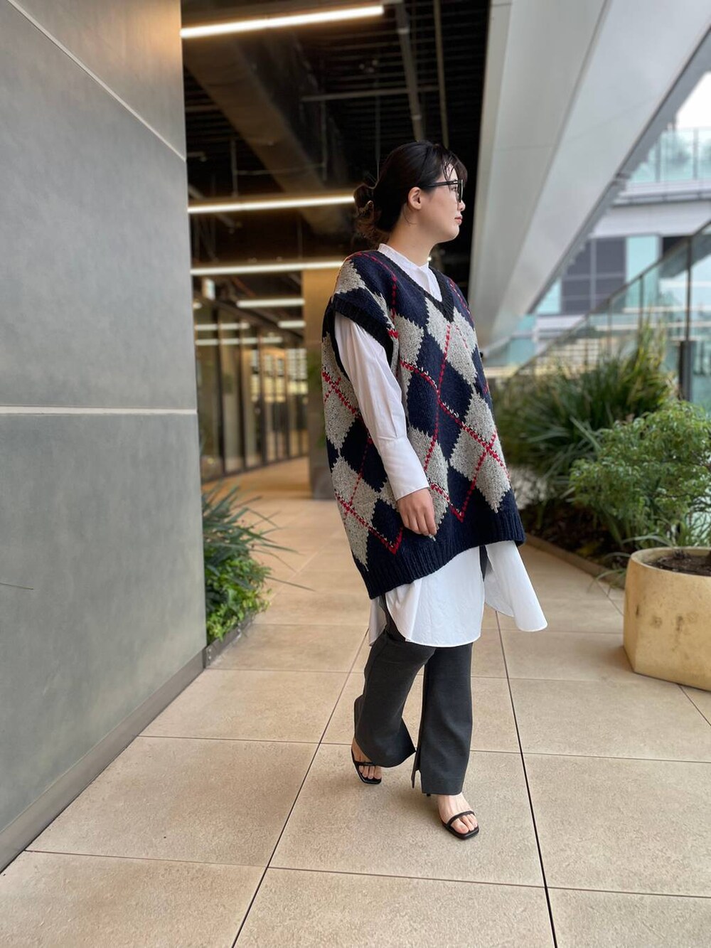 ホワイト系のシャツ/ブラウス、ブルー系のベスト、グレー系のその他パンツを着用したレディースの秋コーディネートの7枚目の写真