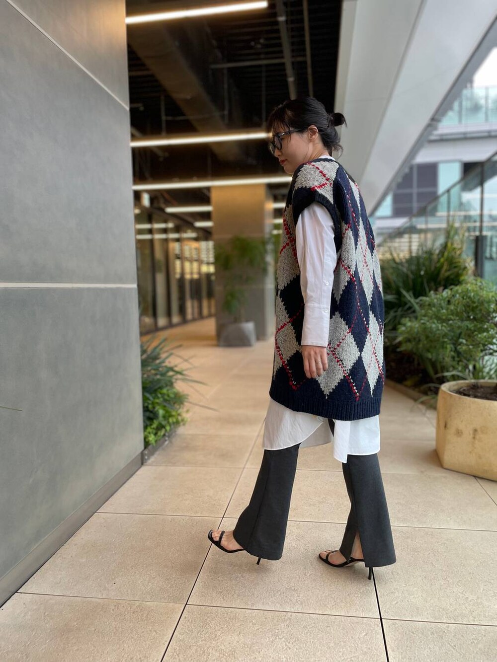 ホワイト系のシャツ/ブラウス、ブルー系のベスト、グレー系のその他パンツを着用したレディースの秋コーディネートの5枚目の写真