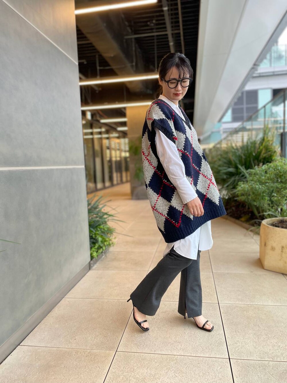 ホワイト系のシャツ/ブラウス、ブルー系のベスト、グレー系のその他パンツを着用したレディースの秋コーディネートの3枚目の写真