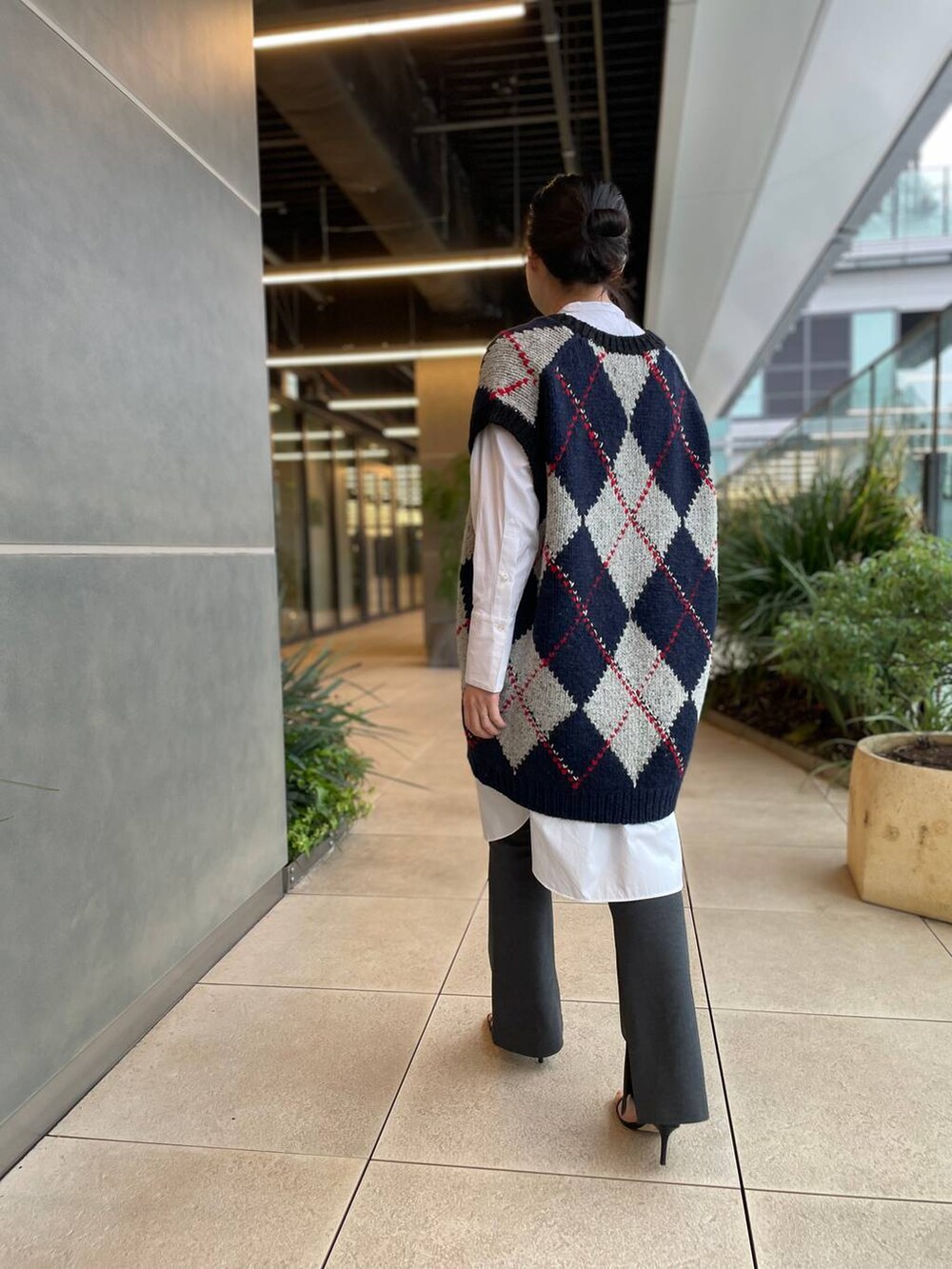 ホワイト系のシャツ/ブラウス、ブルー系のベスト、グレー系のその他パンツを着用したレディースの秋コーディネートの4枚目の写真