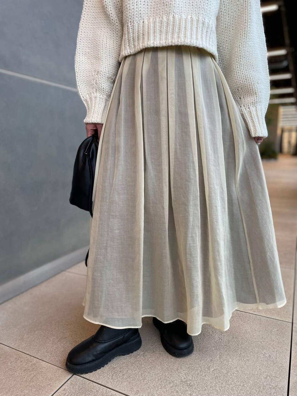 ホワイト系のニット/セーター、ホワイト系のスカートを着用したレディースの秋コーディネートの9枚目の写真