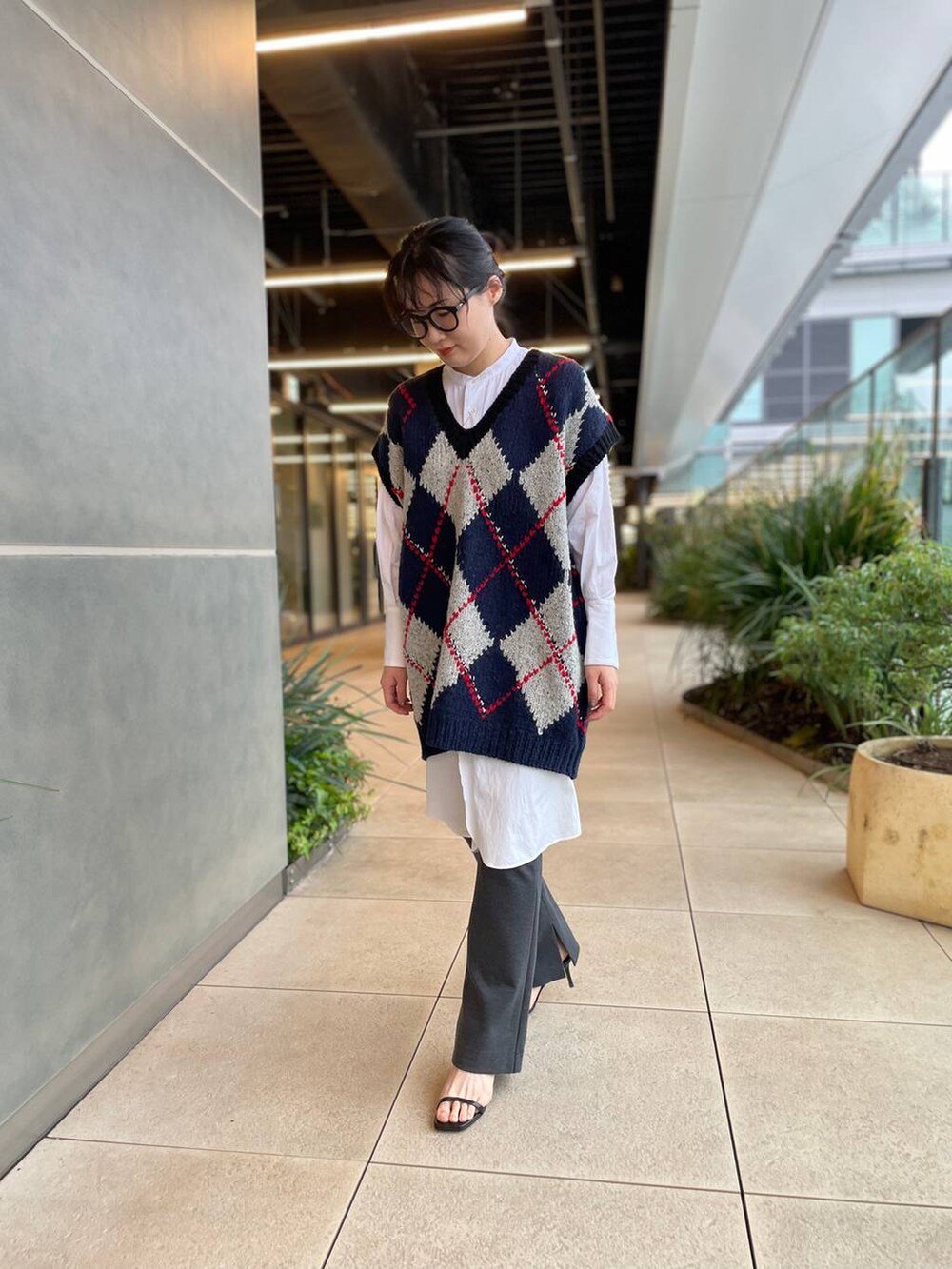 ホワイト系のシャツ/ブラウス、ブルー系のベスト、グレー系のその他パンツを着用したレディースの秋コーディネートの6枚目の写真