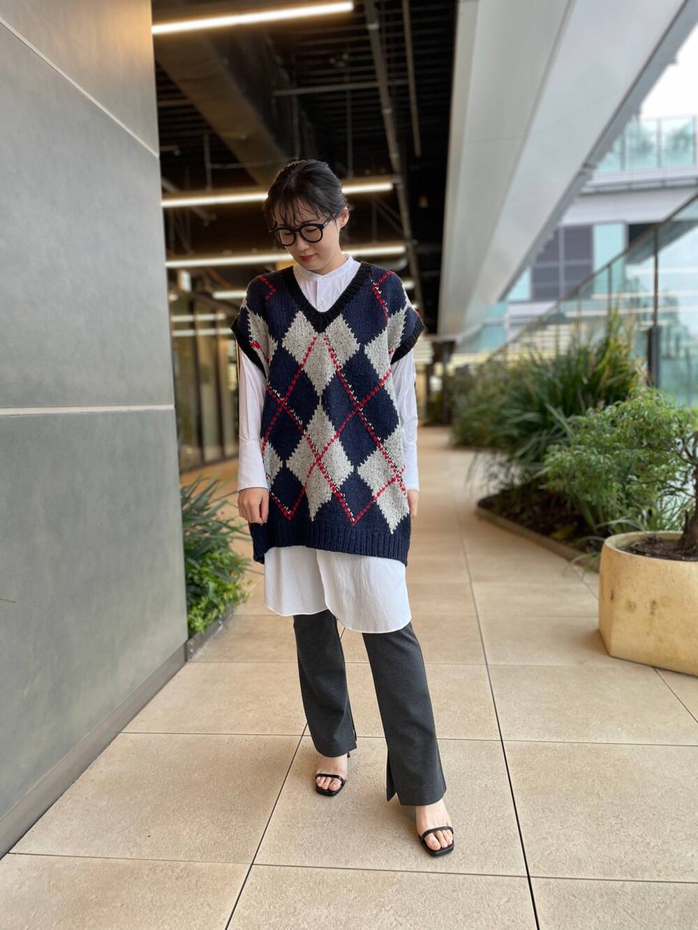 ホワイト系のシャツ/ブラウス、ブルー系のベスト、グレー系のその他パンツを着用したレディースの秋コーディネートの2枚目の写真