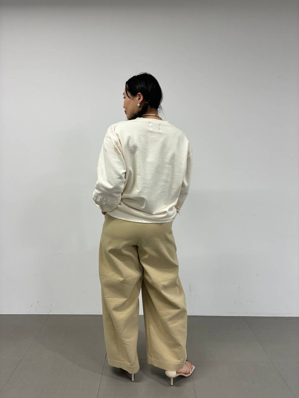 ブラウン系のその他パンツ、シルバー系のピアス（両耳用）を着用したレディースの冬コーディネートの3枚目の写真