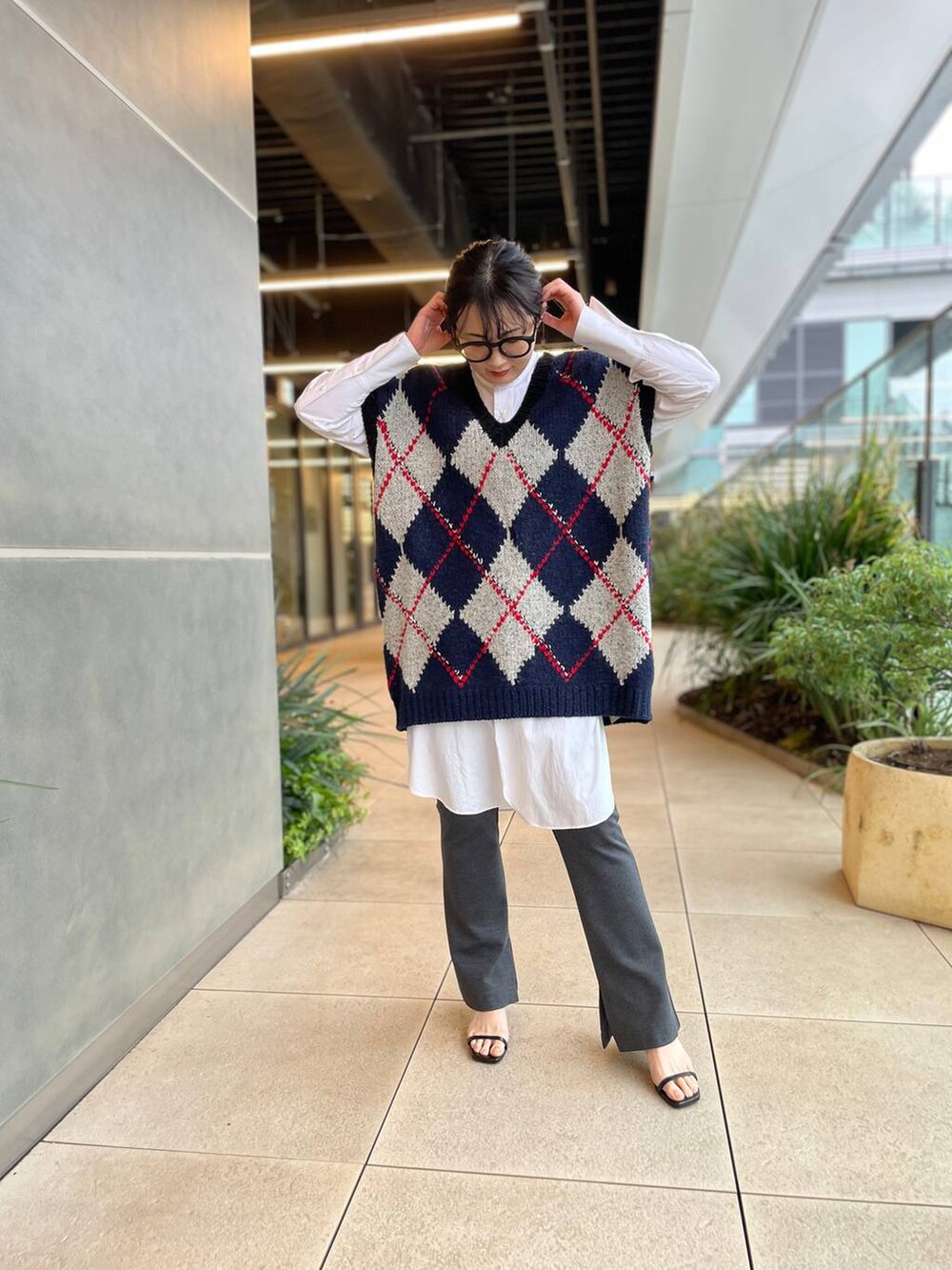 ホワイト系のシャツ/ブラウス、ブルー系のベスト、グレー系のその他パンツを着用したレディースの秋コーディネートの8枚目の写真