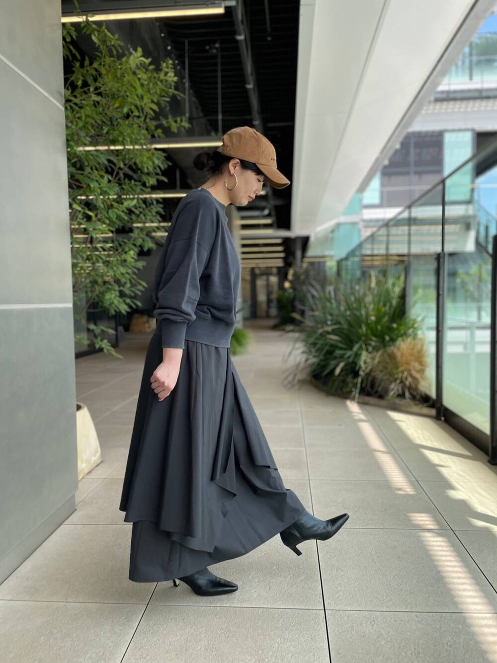 グレー系のスカートを着用したレディースの夏コーディネートの3枚目の写真