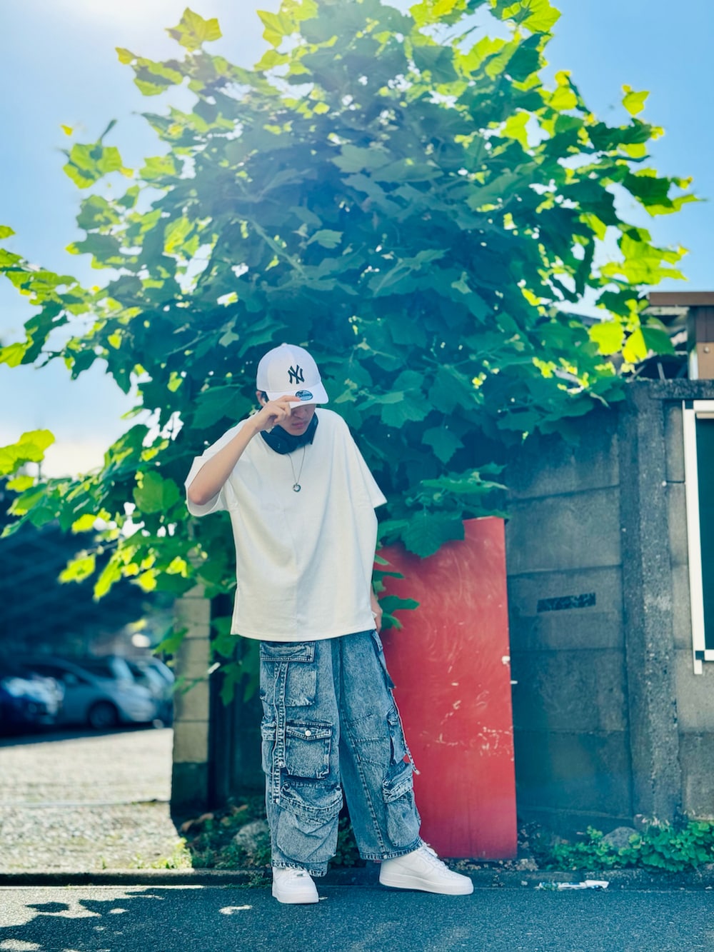 ホワイト系のTシャツ/カットソー、ブルー系のカーゴパンツ、ホワイト系のスニーカーを着用したメンズの夏コーディネートの3枚目の写真