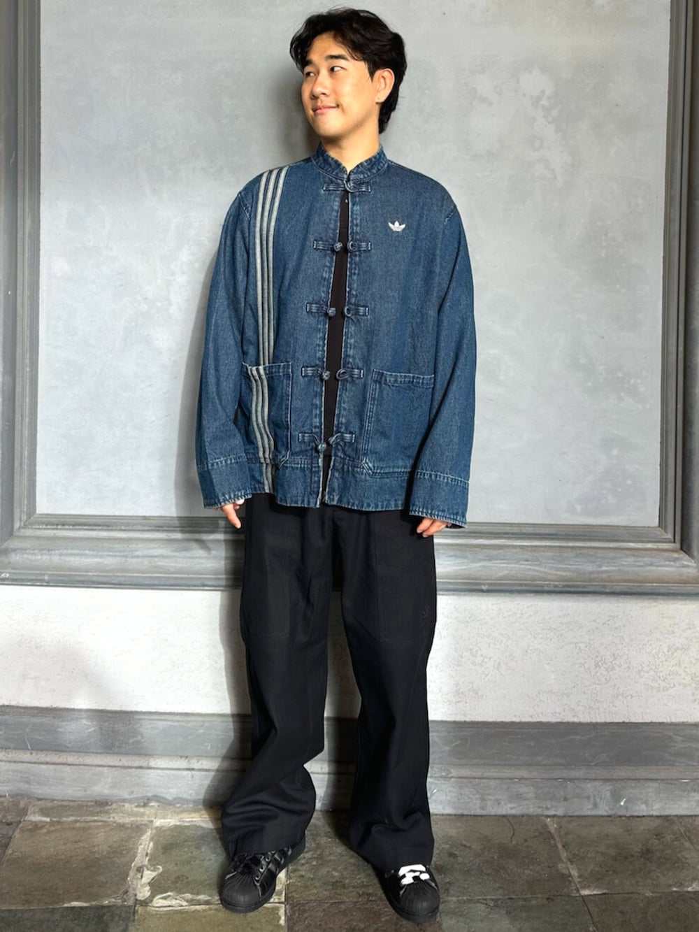 ブルー系のデニムジャケット、ブラック系のスニーカーを着用したメンズの秋コーディネートの3枚目の写真