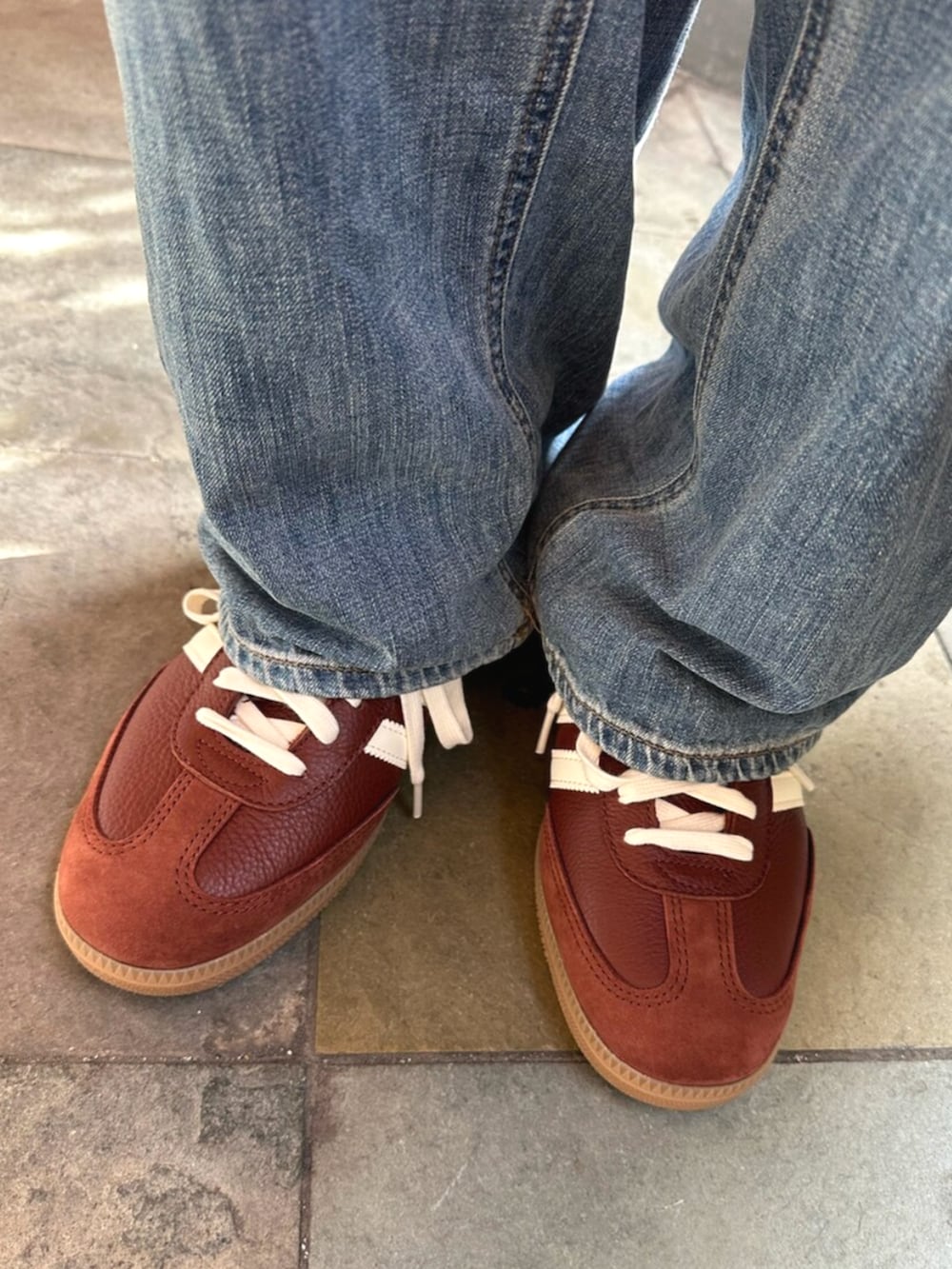 ホワイト系のポロシャツ、ブラウン系のバッグ、ブラウン系のスニーカーを着用したメンズの秋コーディネートの4枚目の写真