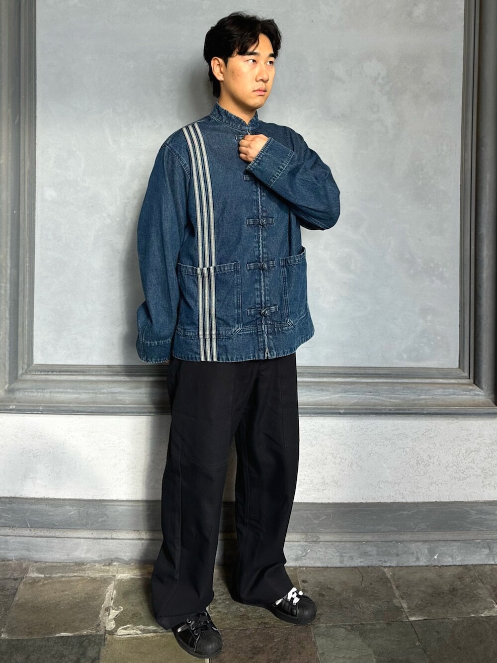 ブルー系のデニムジャケット、ブラック系のスニーカーを着用したメンズの秋コーディネートの2枚目の写真