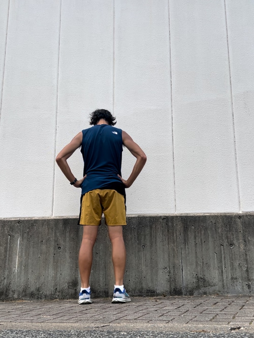 ブルー系のタンクトップ、イエロー系のその他パンツ、ホワイト系のスニーカーを着用したメンズの秋コーディネートの2枚目の写真