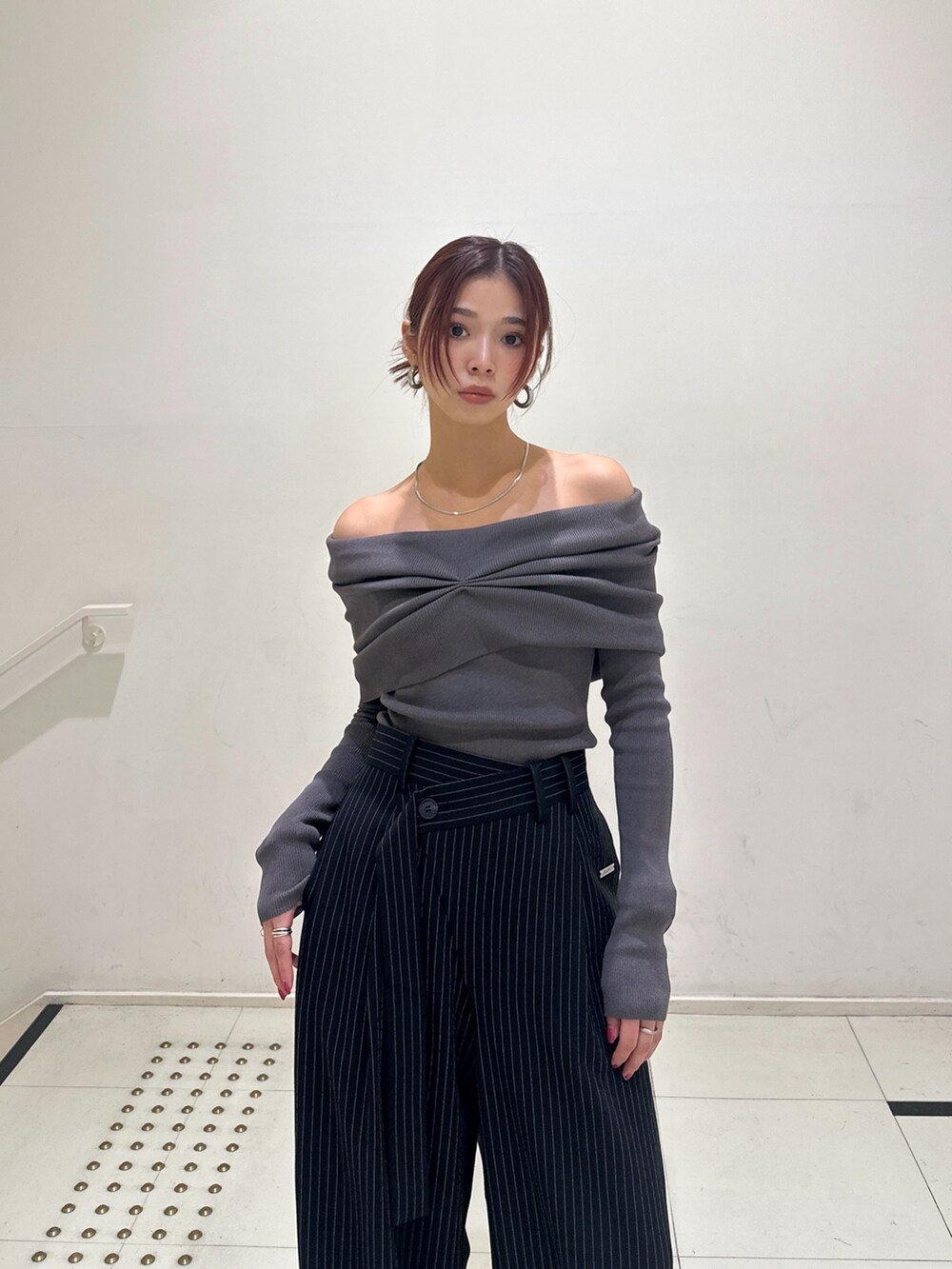 その他のスラックス、ブラック系のブーツ、グレー系のニット/セーターを着用したレディースの秋コーディネートの2枚目の写真