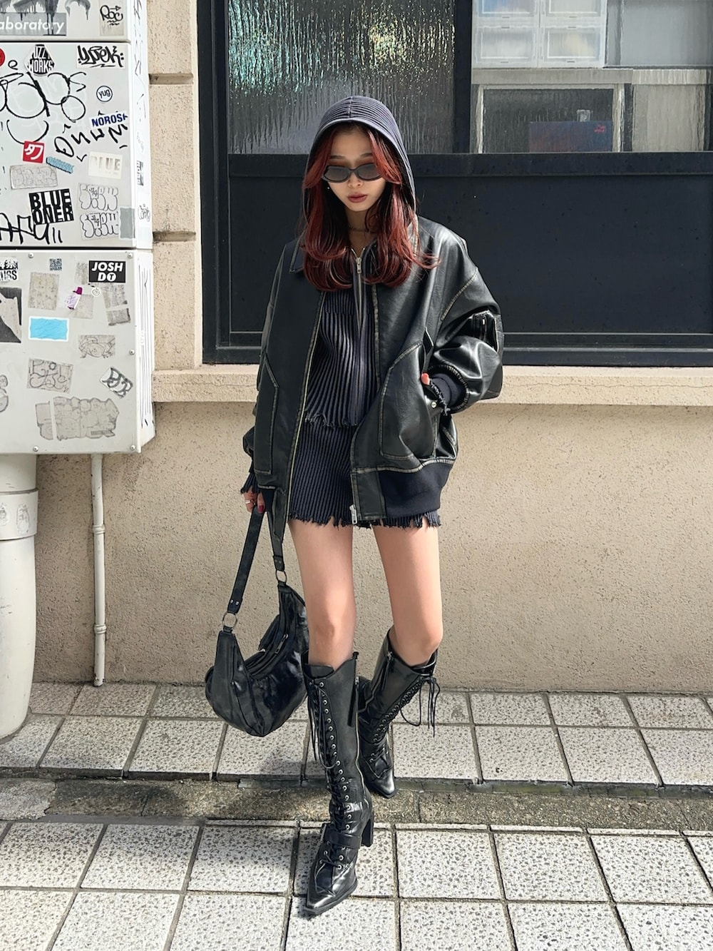 ブラック系のブルゾン、ブラック系のスラックス、ブラック系のパーカーを着用したレディースの秋コーディネートの2枚目の写真