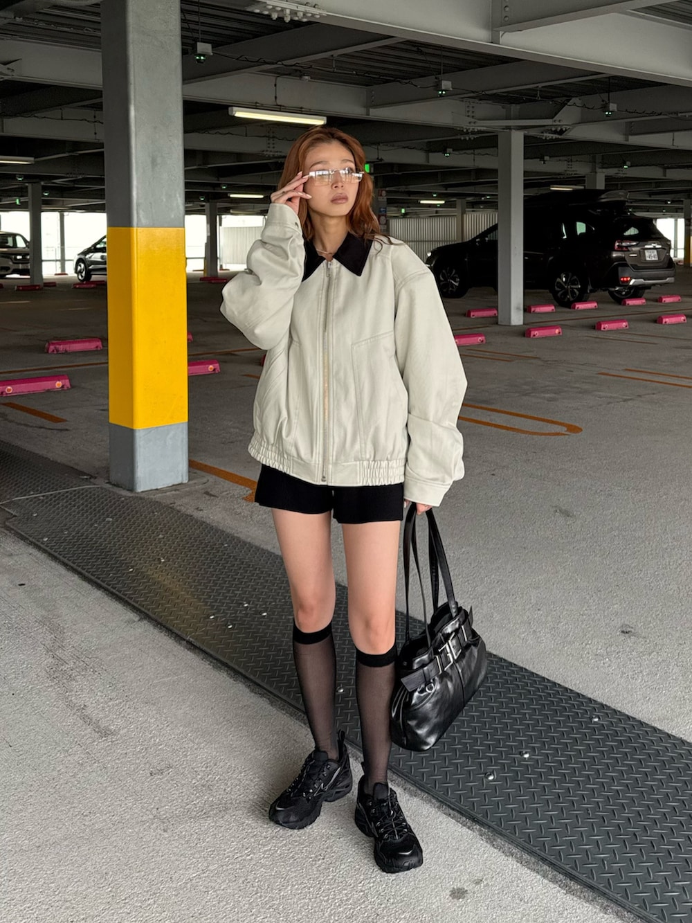 ベージュ系のブルゾン、ブラック系のショルダーバッグ、ブラック系のスラックスを着用したレディースの秋コーディネートの2枚目の写真