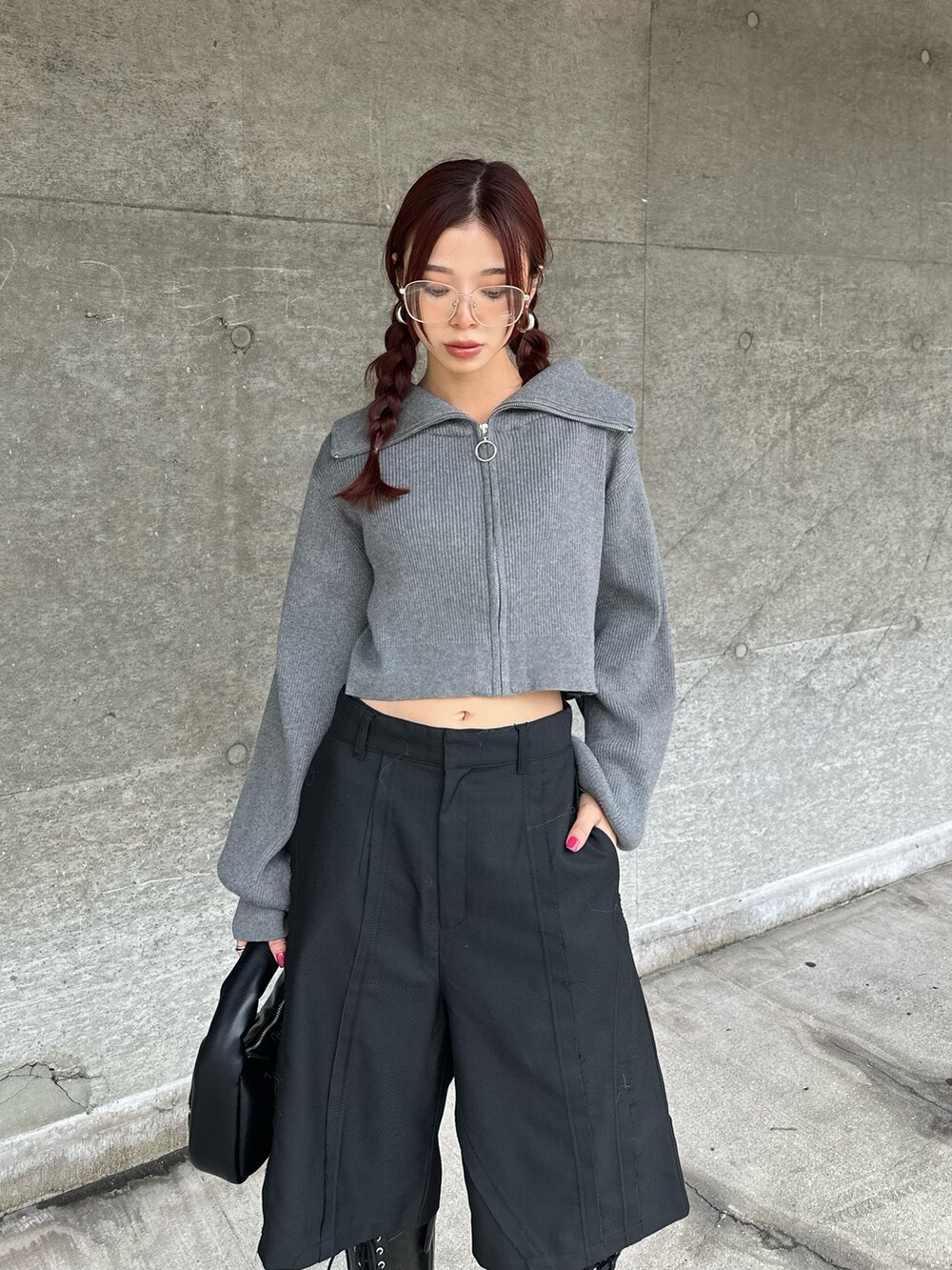 ブラック系のブーツ、ブラック系のスラックス、グレー系のニット/セーターを着用したレディースの秋コーディネートの3枚目の写真