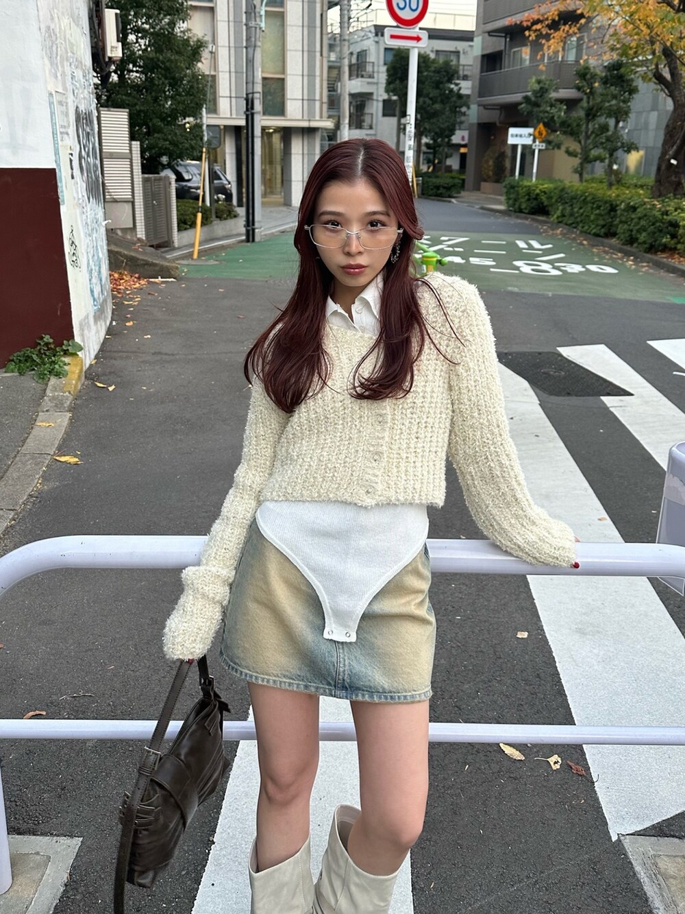 ブラウン系のハンドバッグ、ホワイト系のカーディガン/ボレロ、ホワイト系のニット/セーターを着用したレディースの冬コーディネートの3枚目の写真